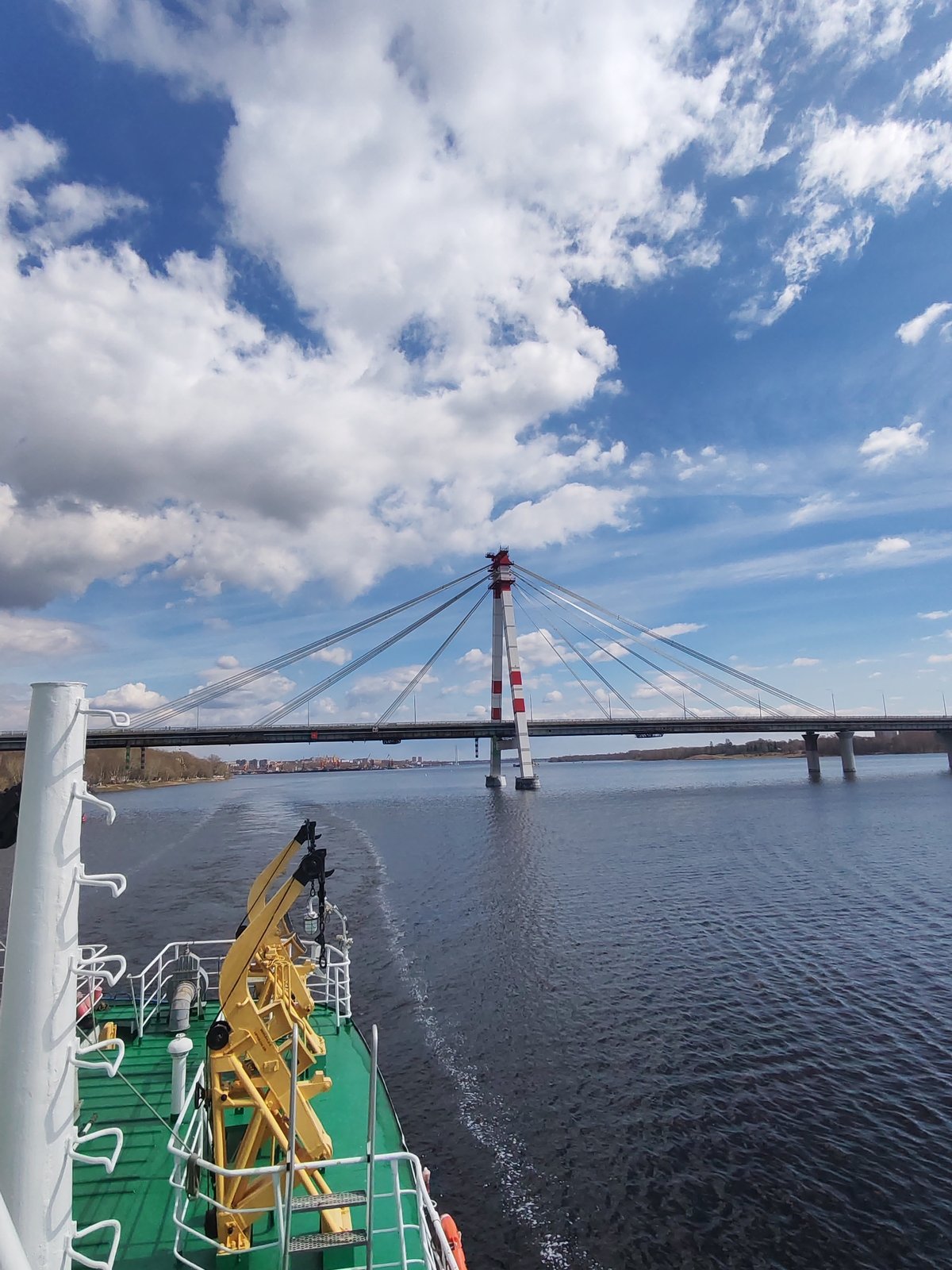 Cargo vessel documents morning river transit past cable-stayed bridge