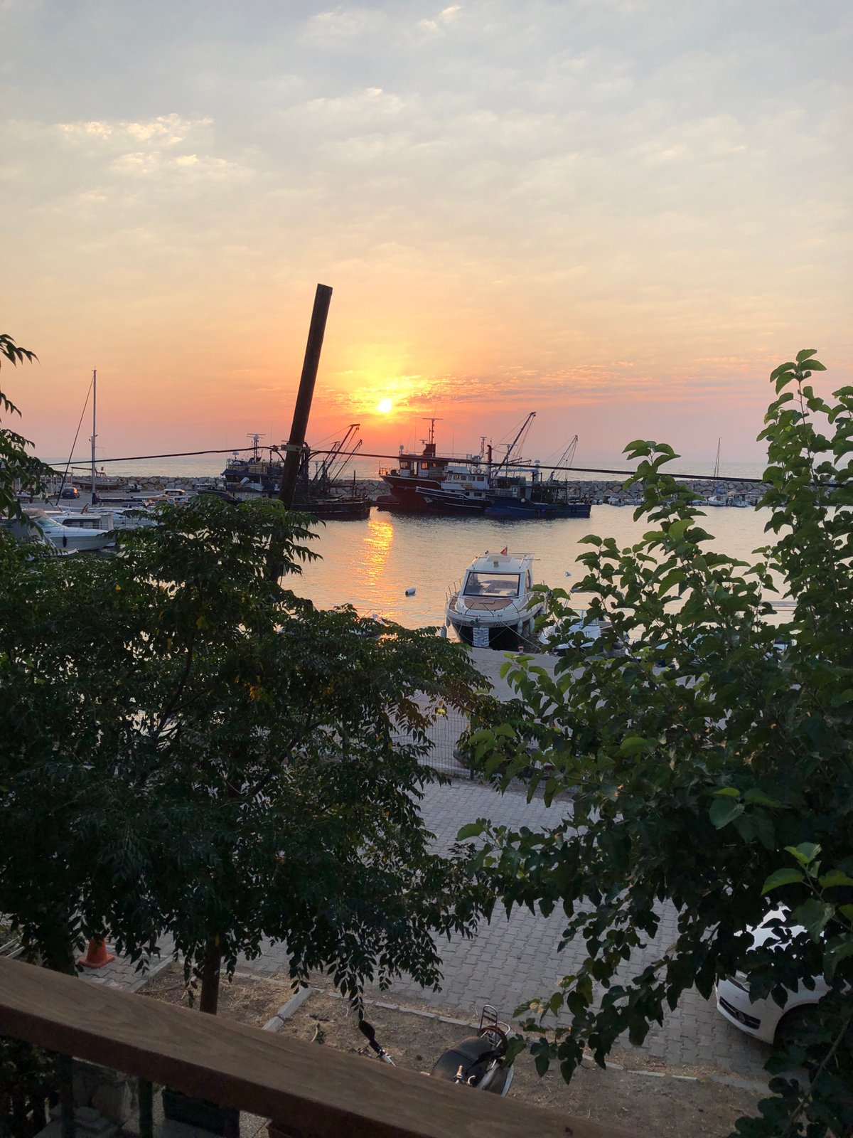 Sunset over Karaburun harbor, fishing boats at rest