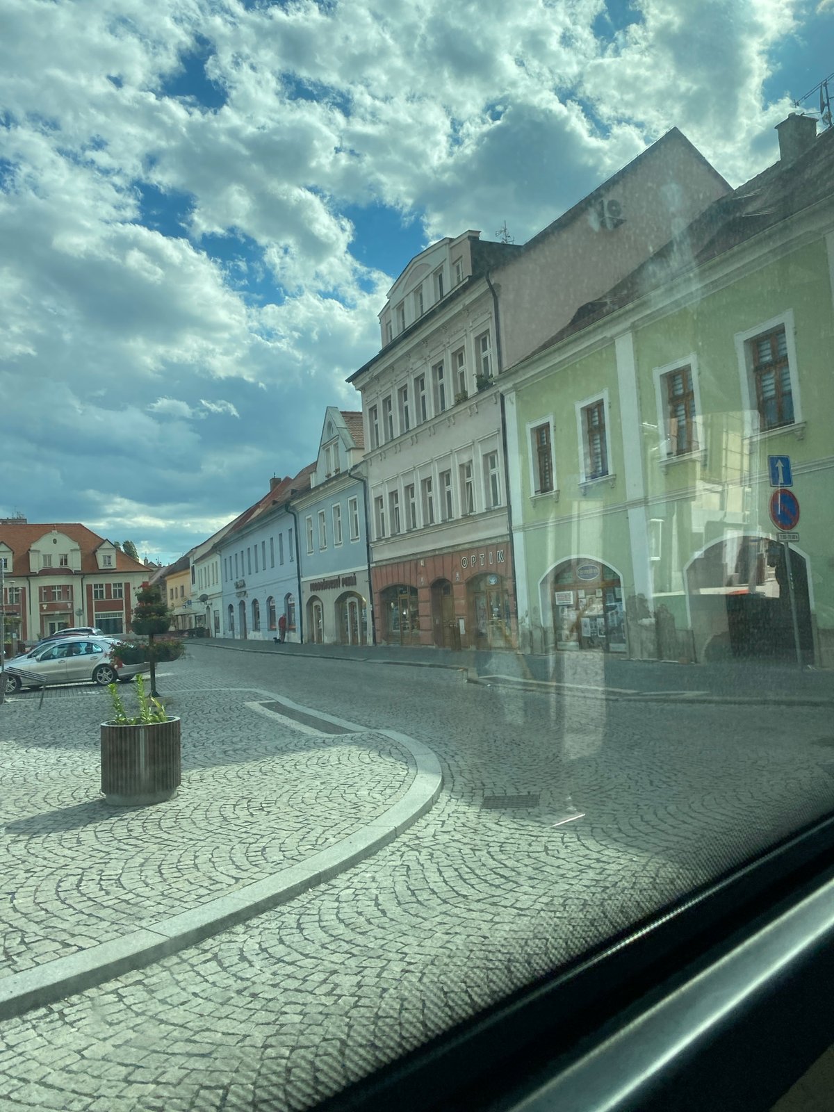 Transit journey through historic Bílina cobblestone streets and square