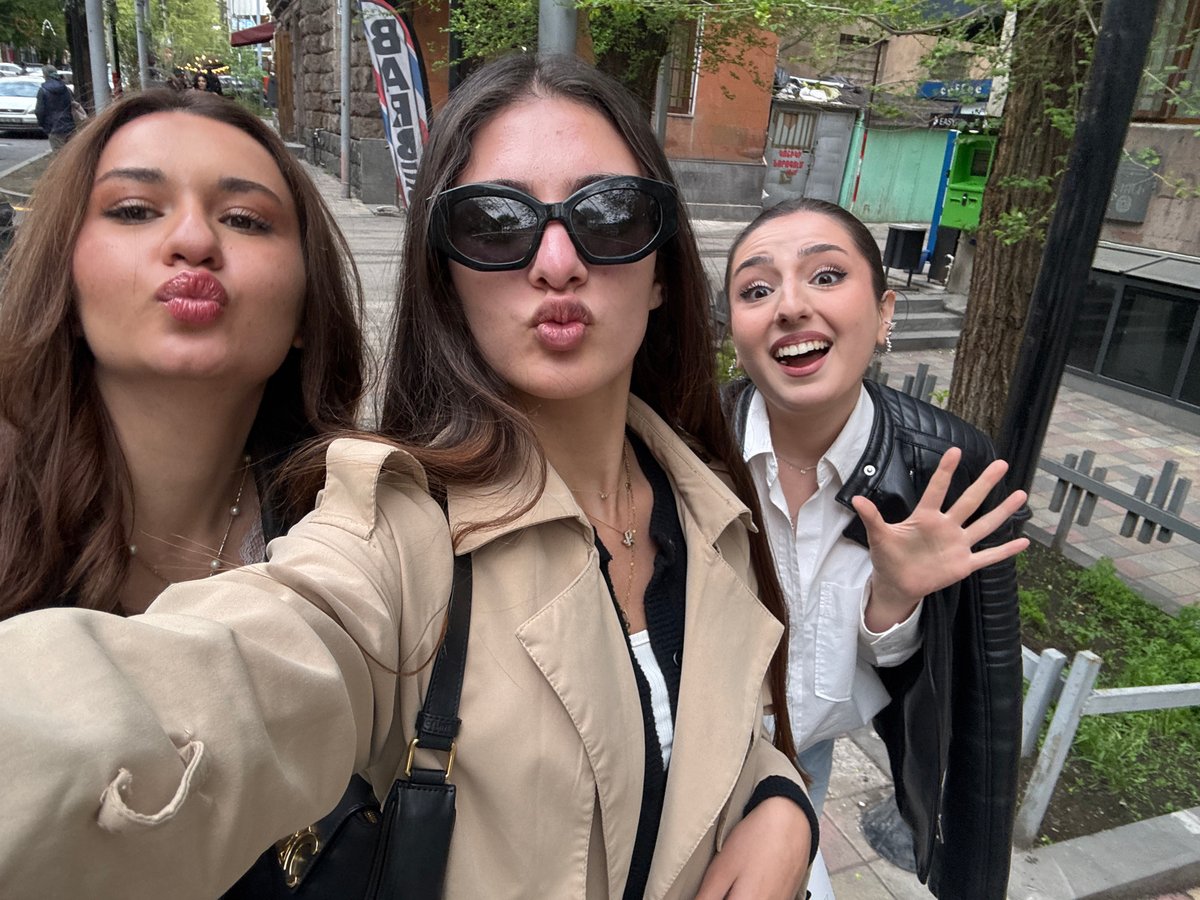 Three women take playful outdoor selfie