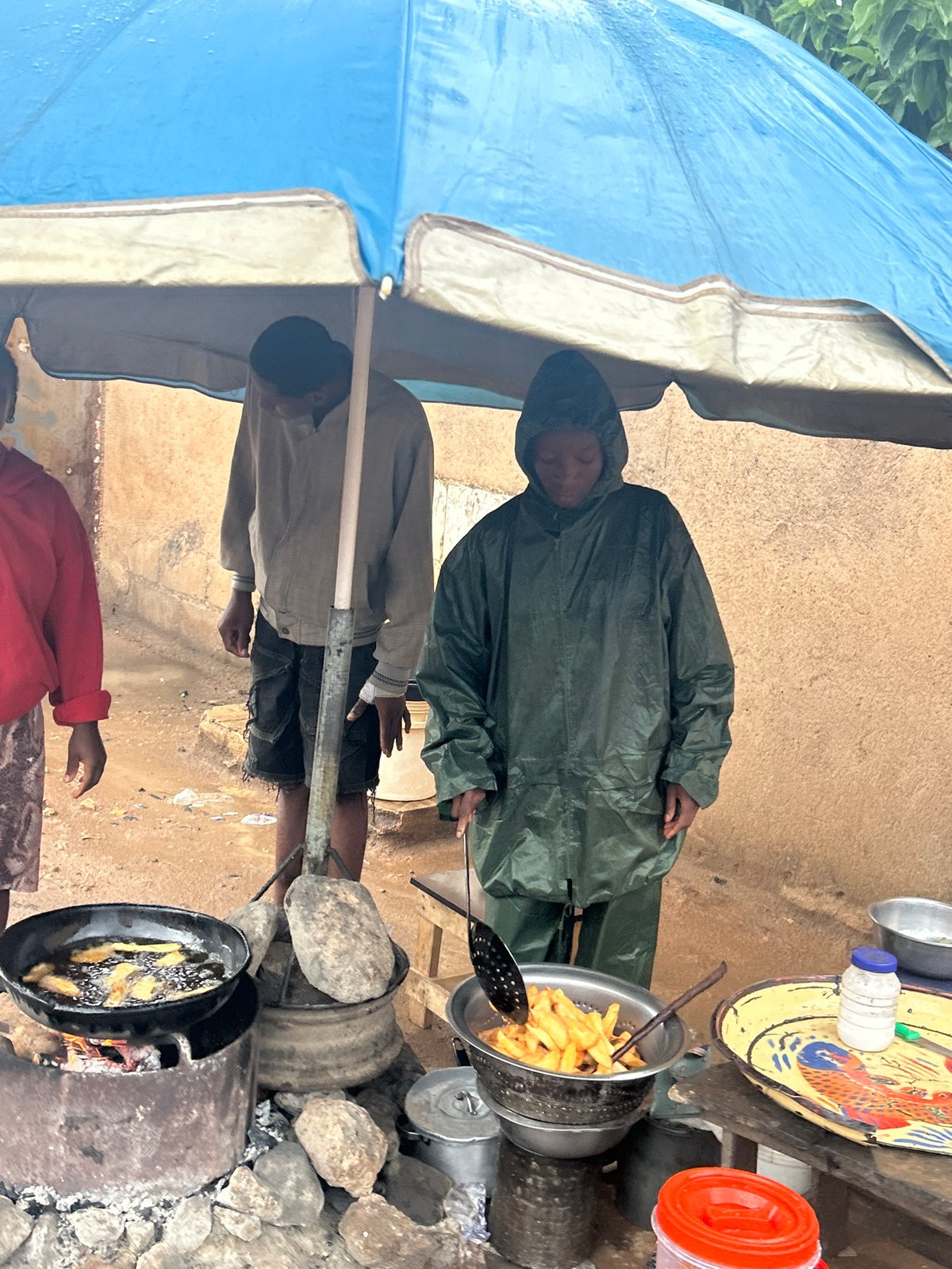 Street food vendors serve customers under tarps in Jos