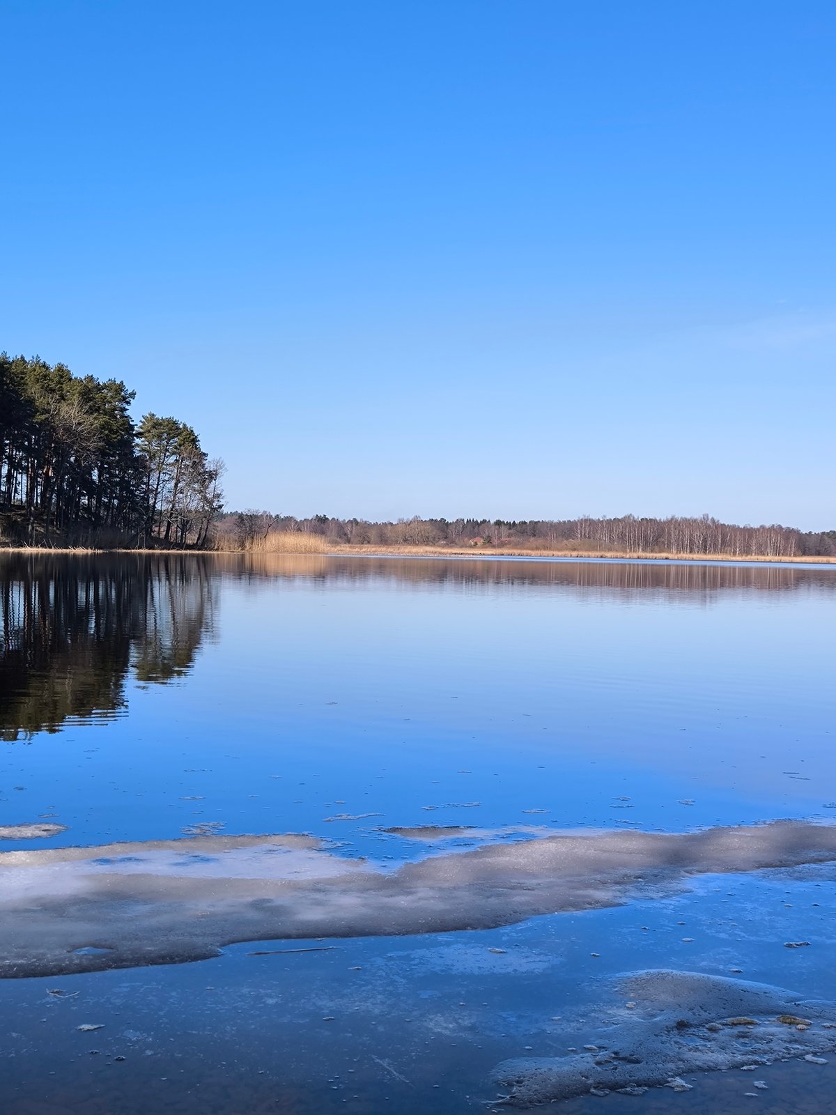 Clear skies over peaceful lake captured in Spuņciems, Latvia