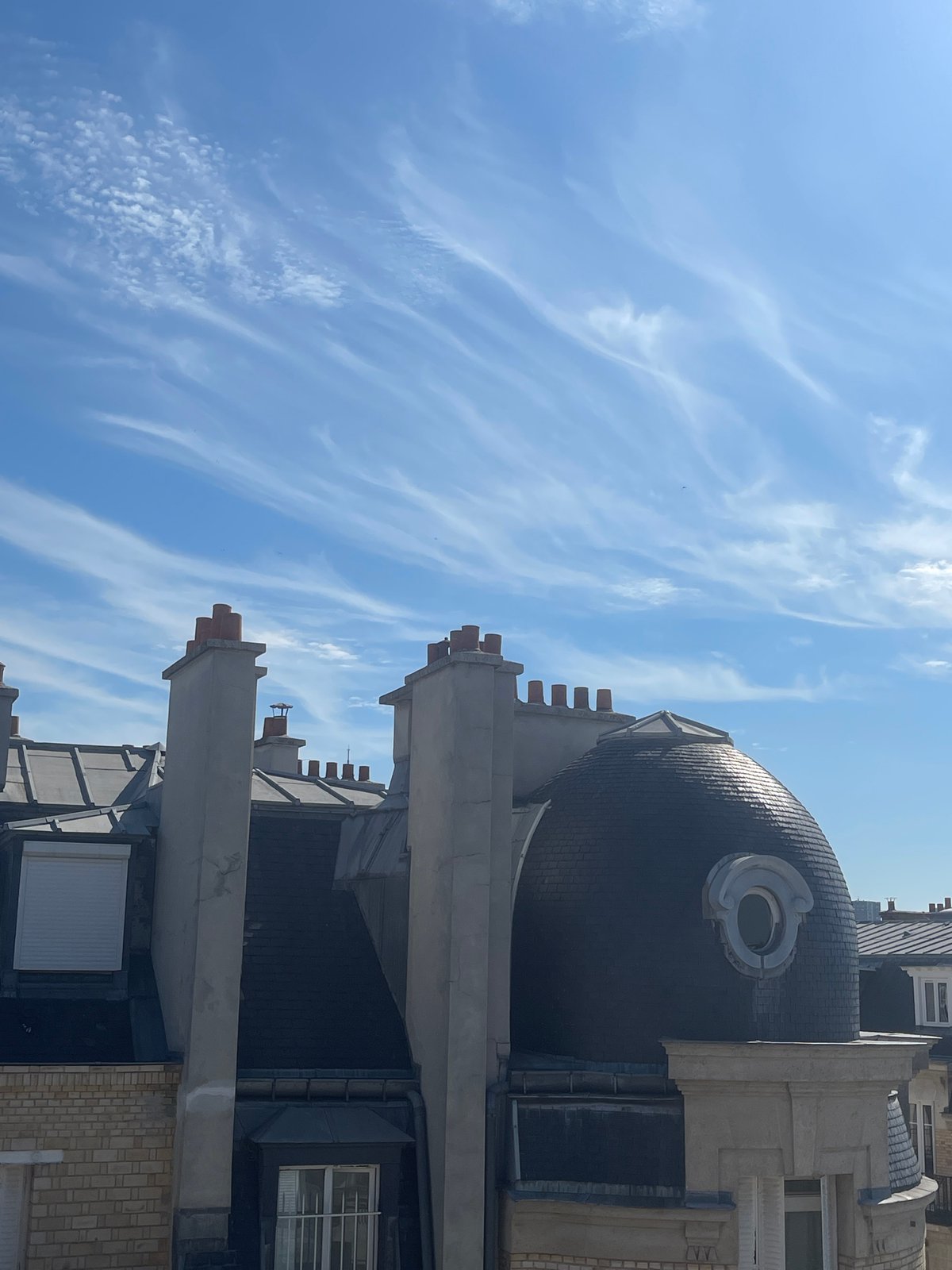 Paris rooftops on a clear summer morning, classic architecture overhead