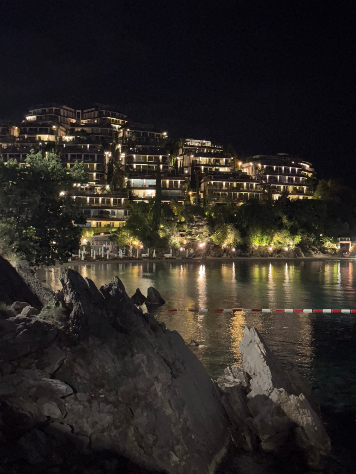 Evening lights illuminate Budva waterfront cafes and residential areas