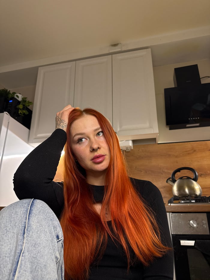 Red-haired woman documents afternoon at home in Rostov-on-Don
