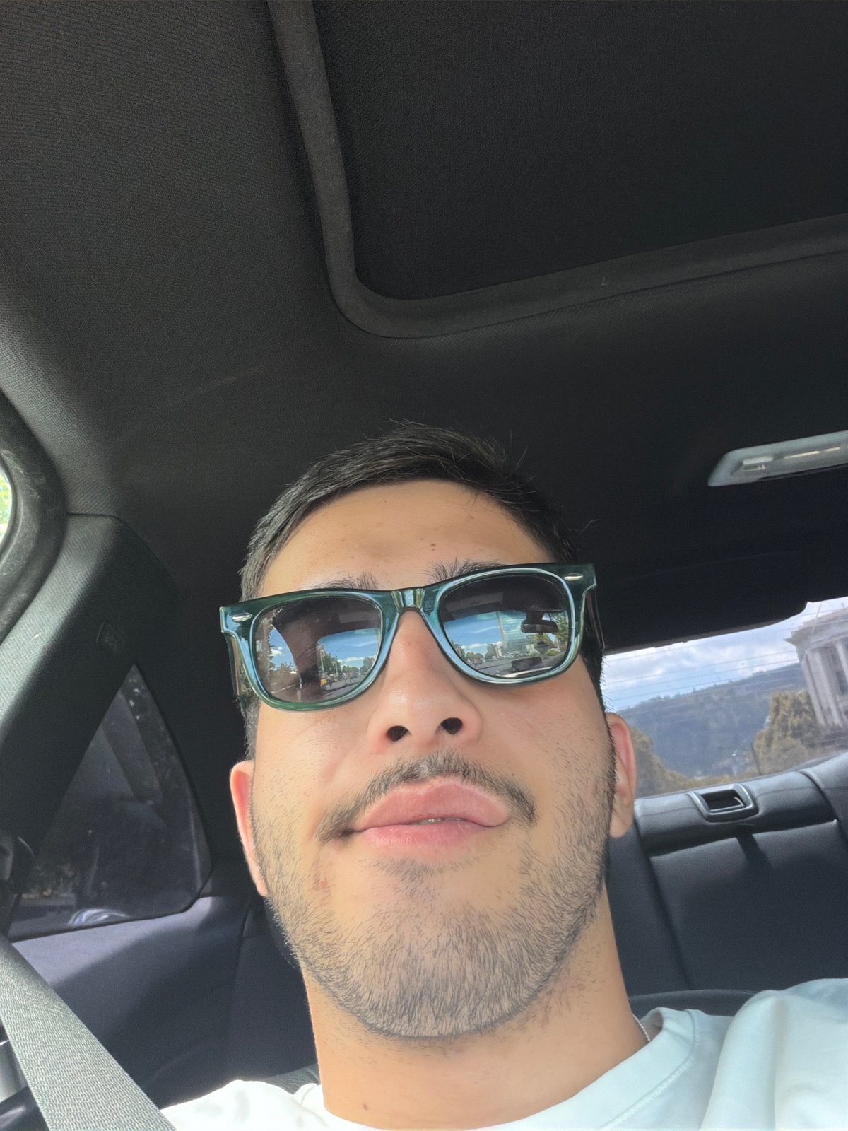 Behind the wheel in Tbilisi, sunglasses reflecting the street
