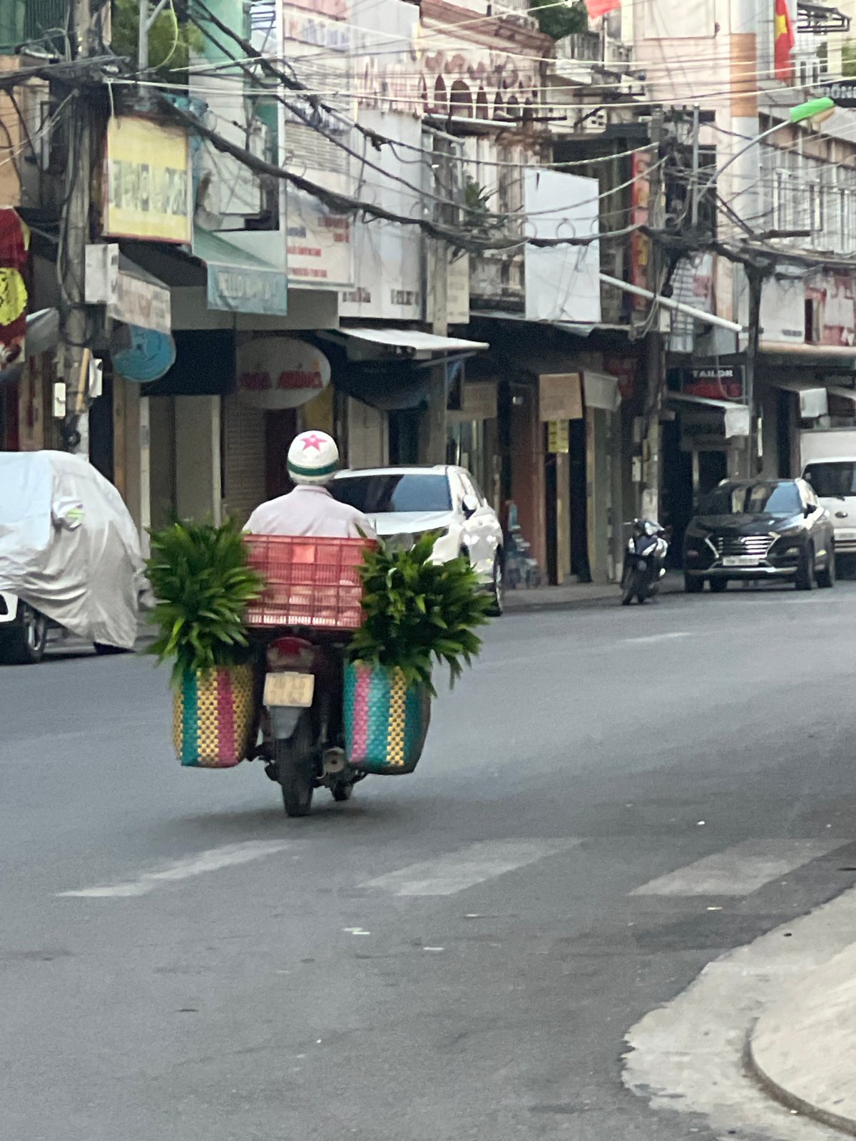 Evening street life in Nha Trang, motorcycles, EVs, and city storefronts