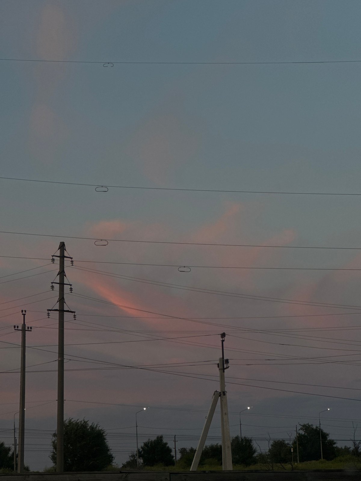 Power lines and utility poles against a fading twilight sky