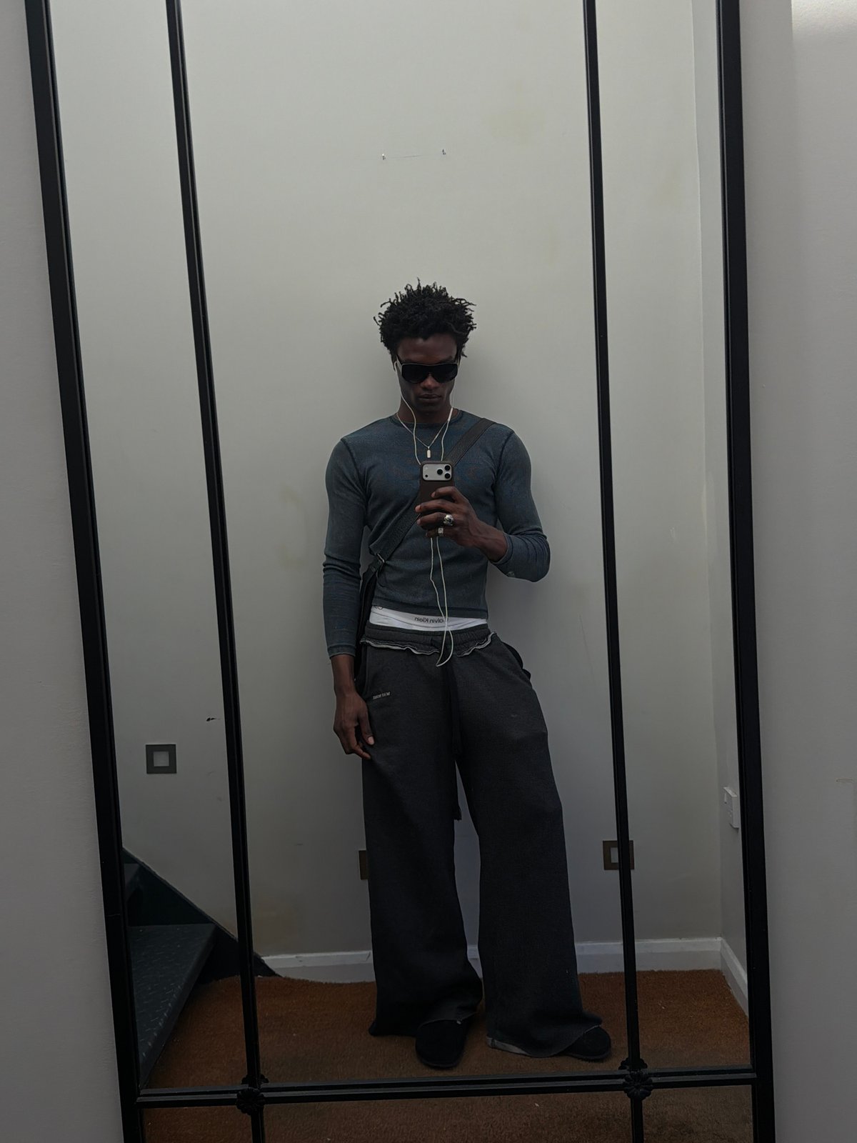 Man in grey clothing observed at mirror in London