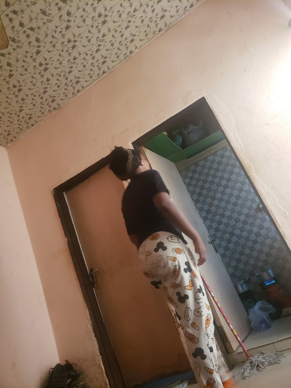 Person observed through opening in Rido, Nigeria indoor scene