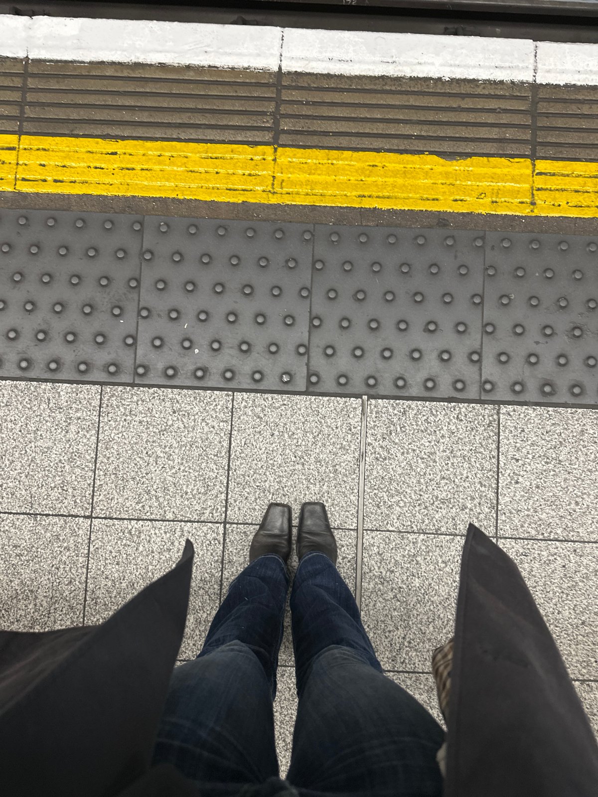 Commuter waits on London Underground platform during morning hours