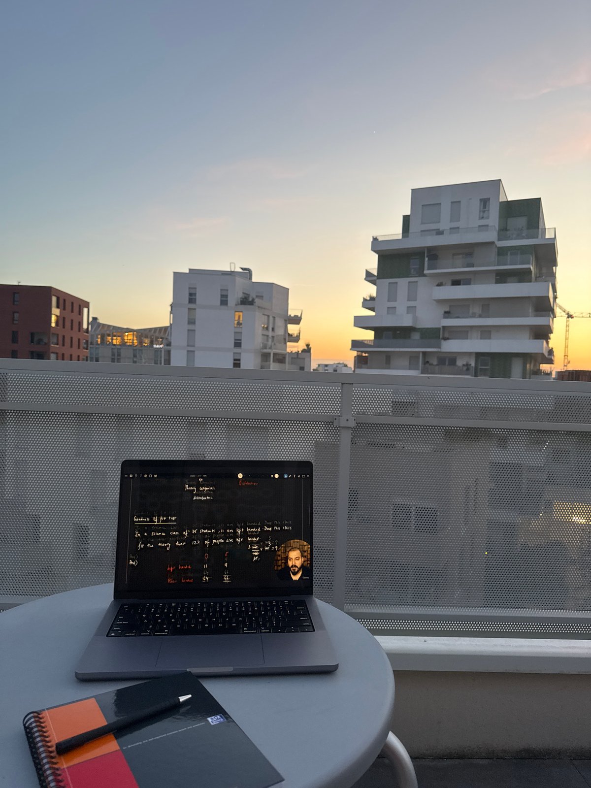 Evening laptop work session captured on Toulouse balcony at sunset