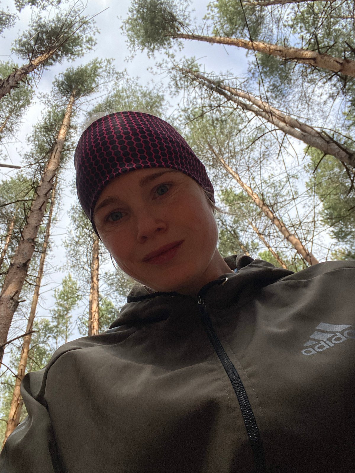 Woman takes early morning selfie in Russian pine forest
