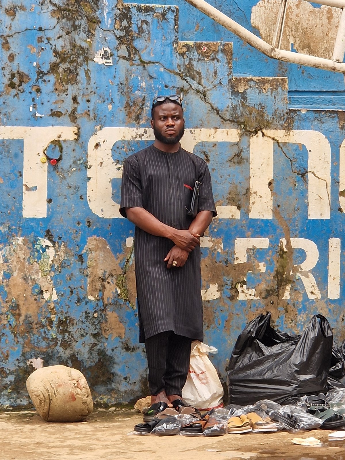 Street life near a Technicolor Nigeria storefront on a busy urban day