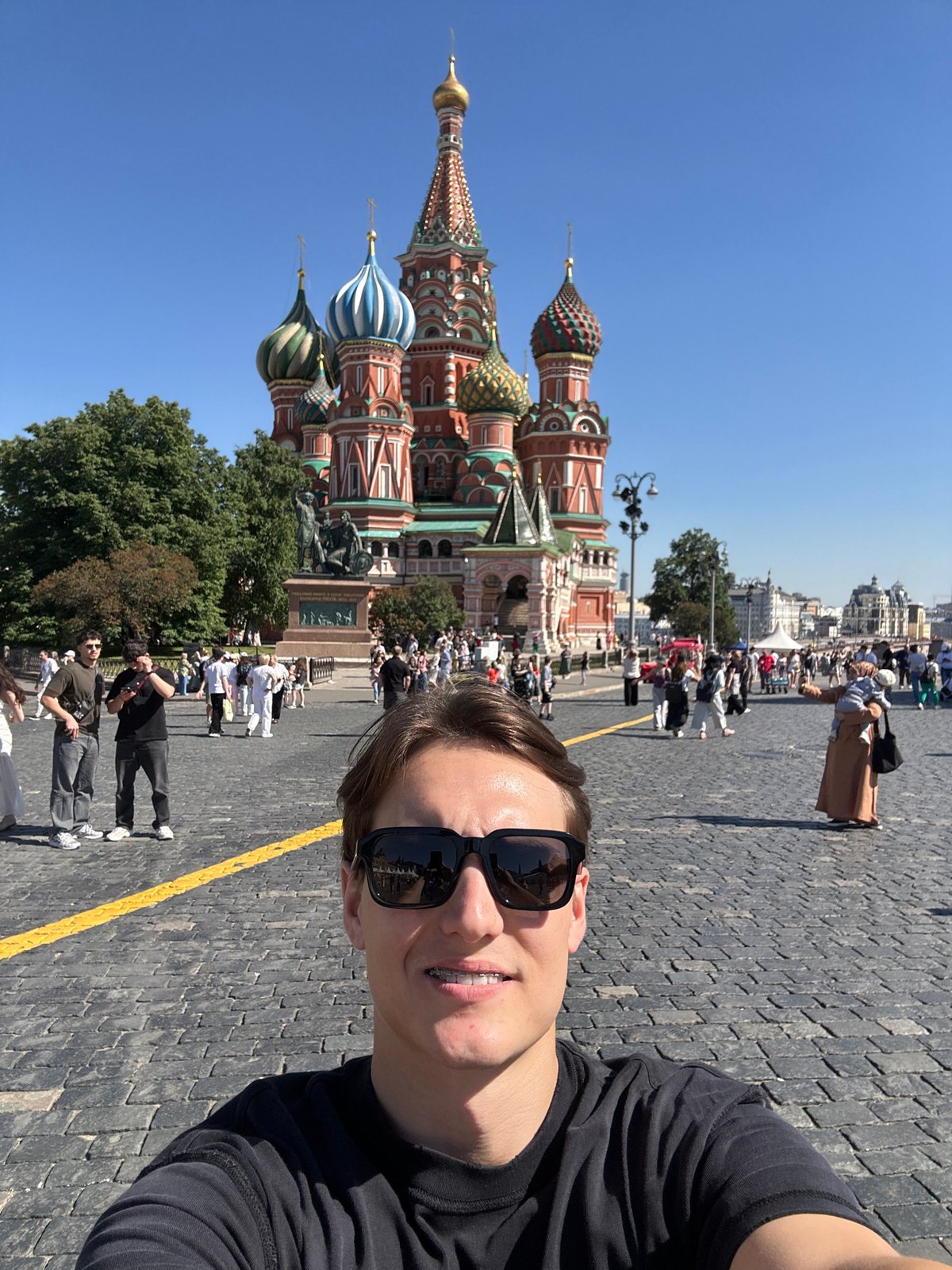Tourist photographs Red Square landmarks on sunny afternoon