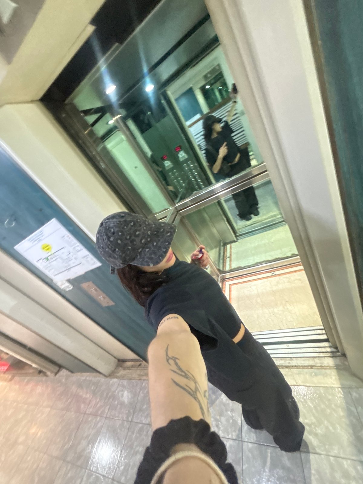 Person with tattoo, patterned cap observed in Buenos Aires elevator