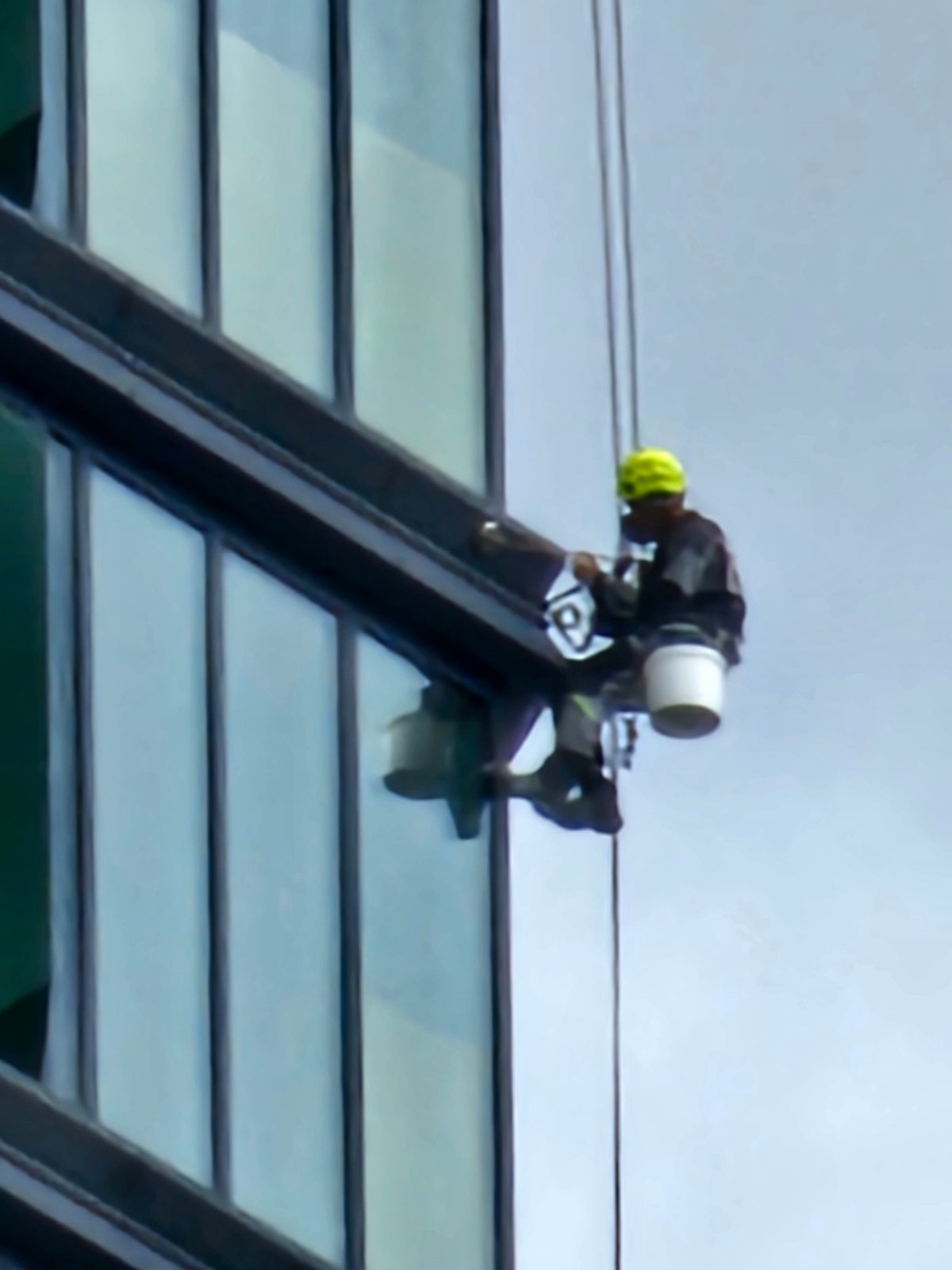 Rope-suspended crews service a Moscow glass skyscraper's exterior