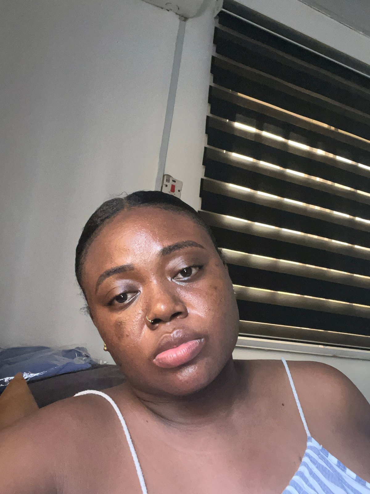 Woman photographed indoors in Abuja bedroom setting