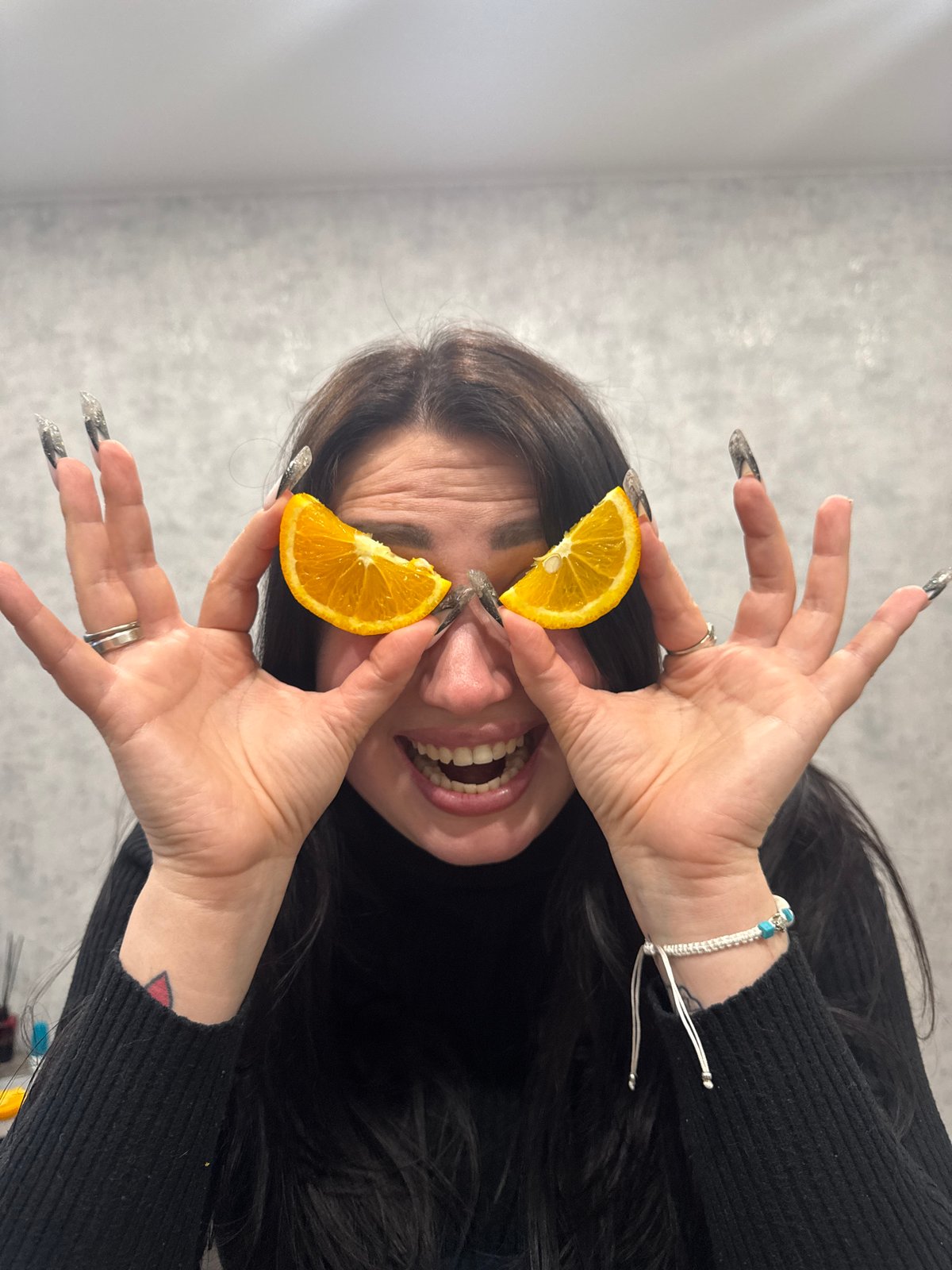 Person poses with orange slices during casual photo session
