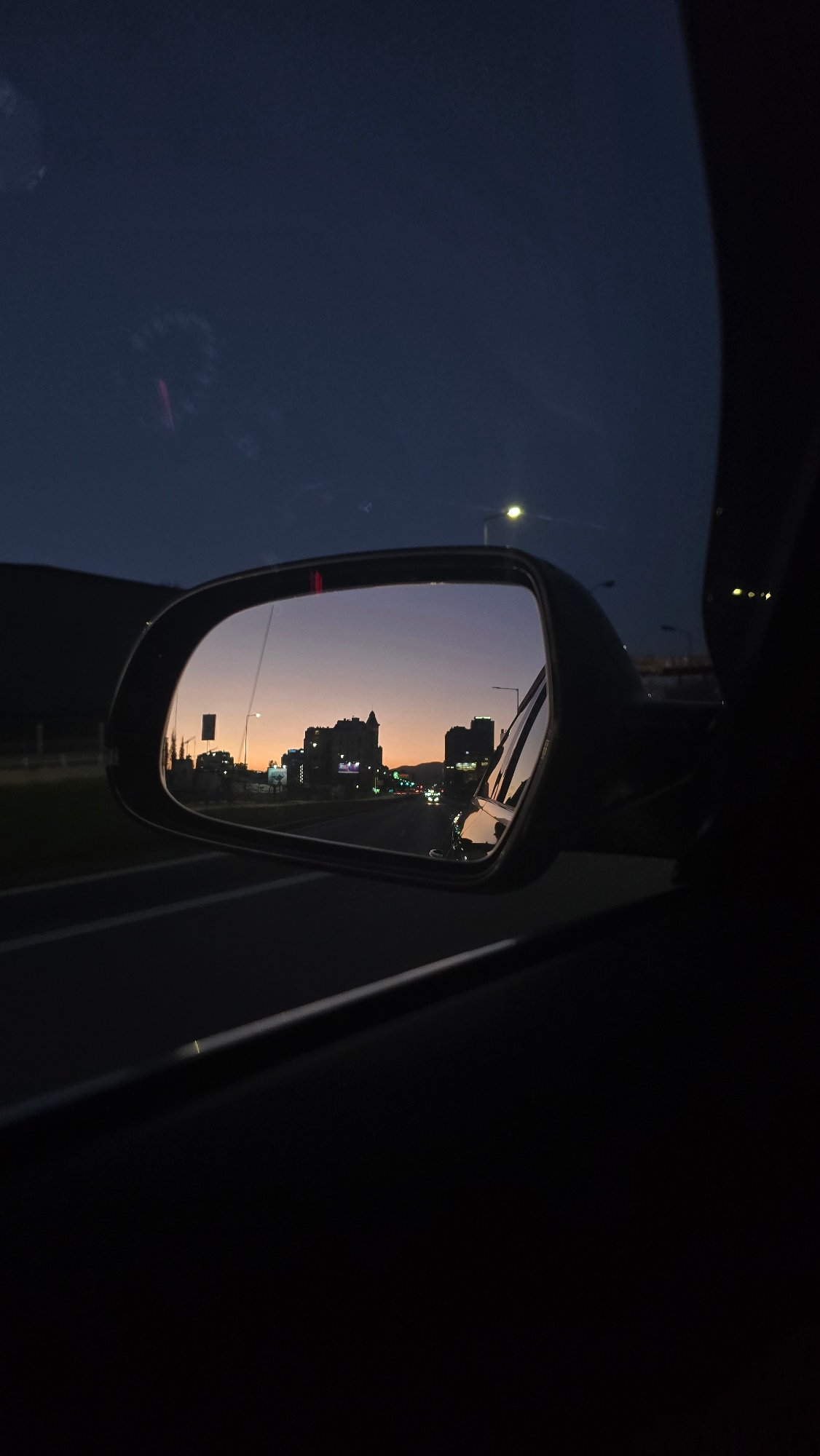 Evening cityscape reflected in car mirror, Sofia Bulgaria