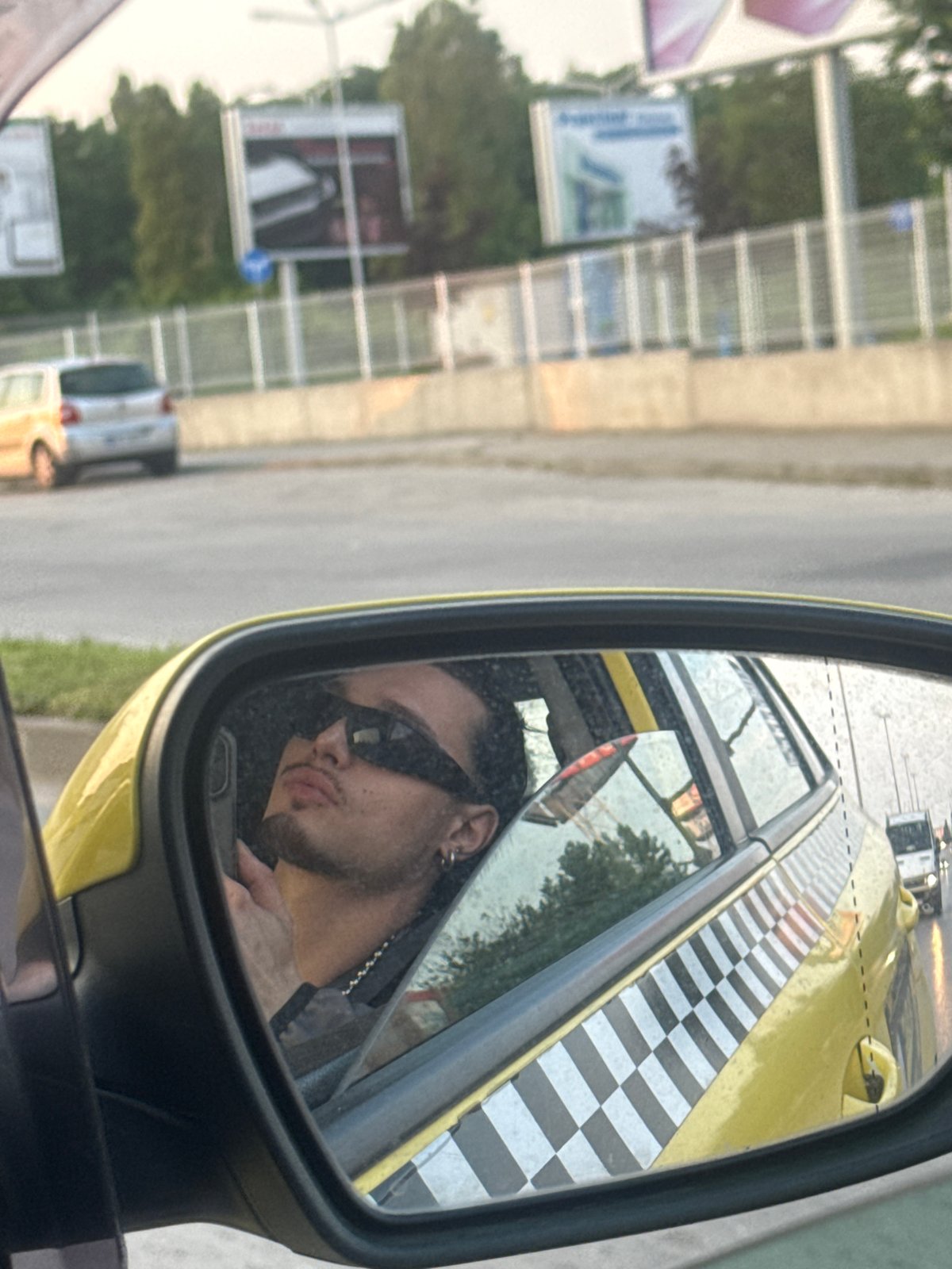 Man with sunglasses spotted in yellow vehicle mirror in Sofia