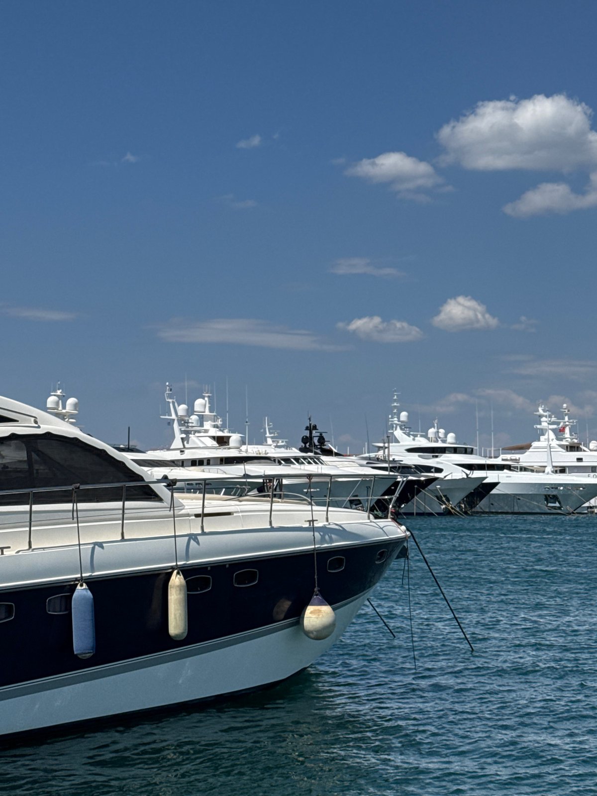 Luxury yachts lined up at a sunny Moschato marina