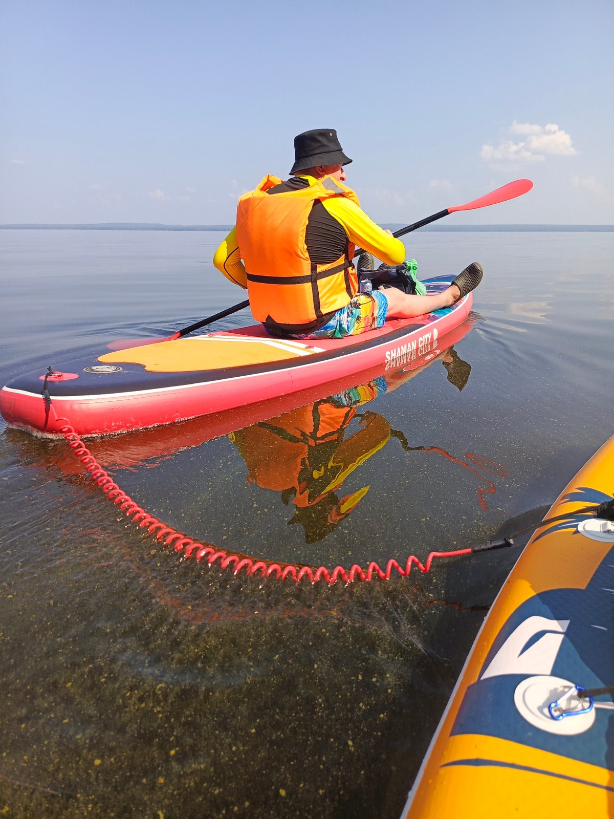 Summer paddleboarding along Chaikovsky's steep riverbanks