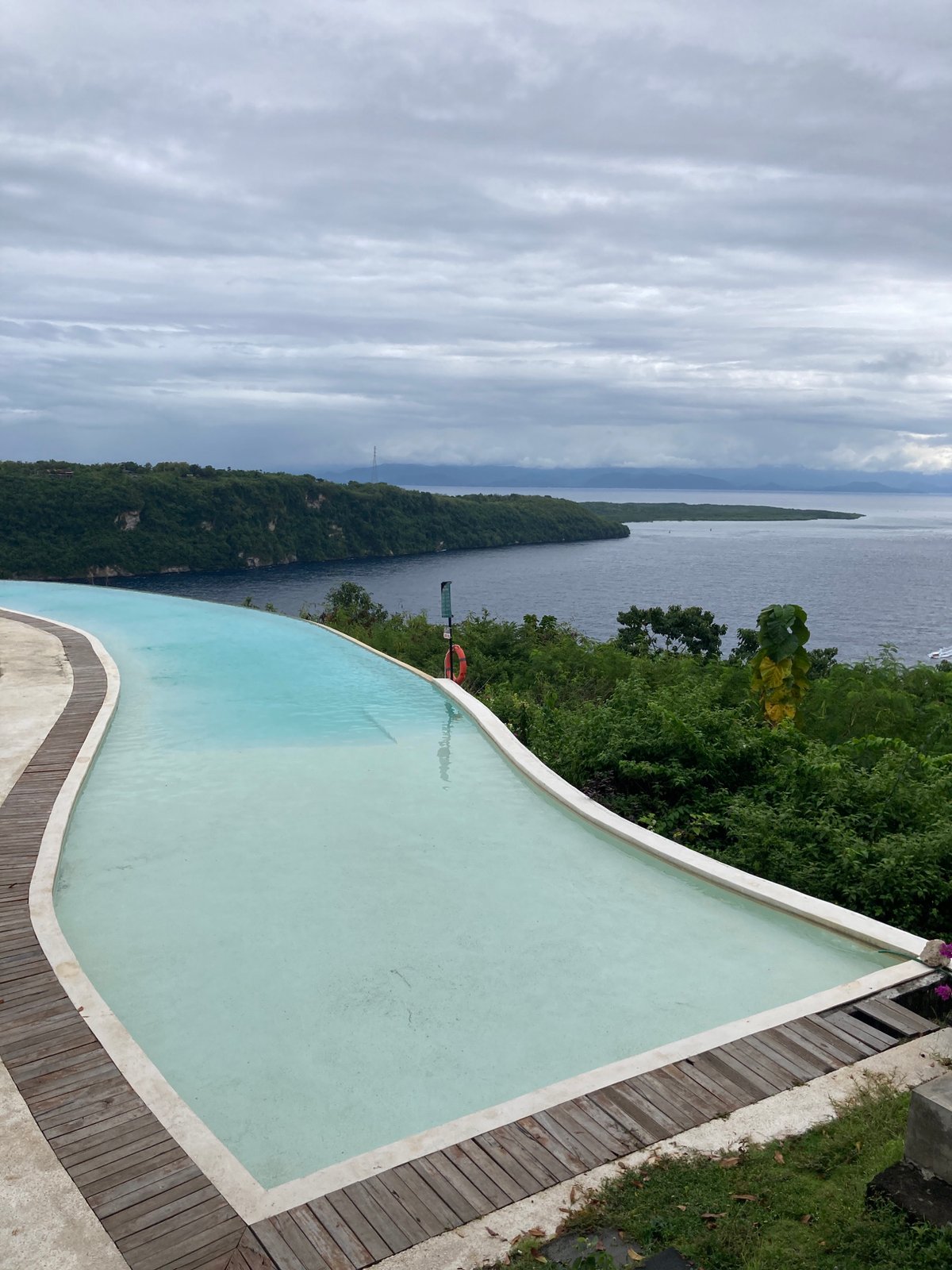 Tropical infinity pool and coastal hillside captured in early morning