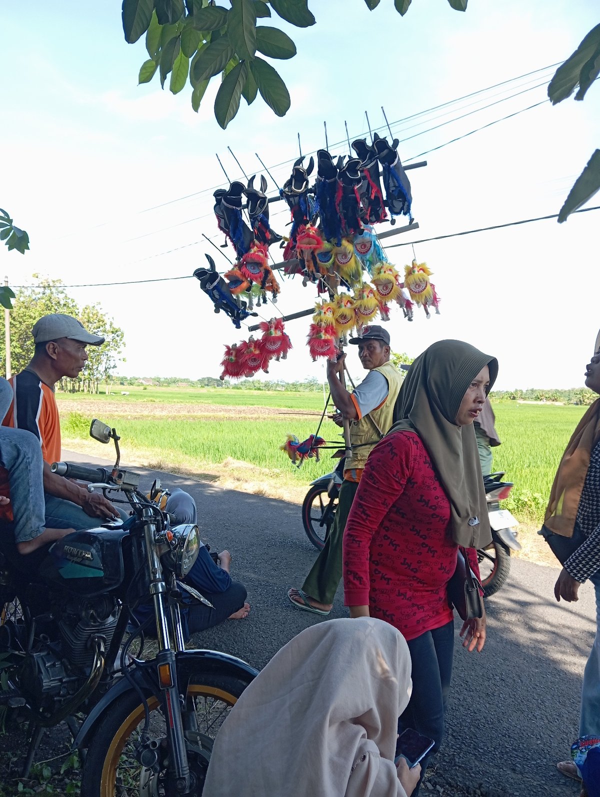 Community gathering with families, vendors, procession in rural Waung, Indonesia