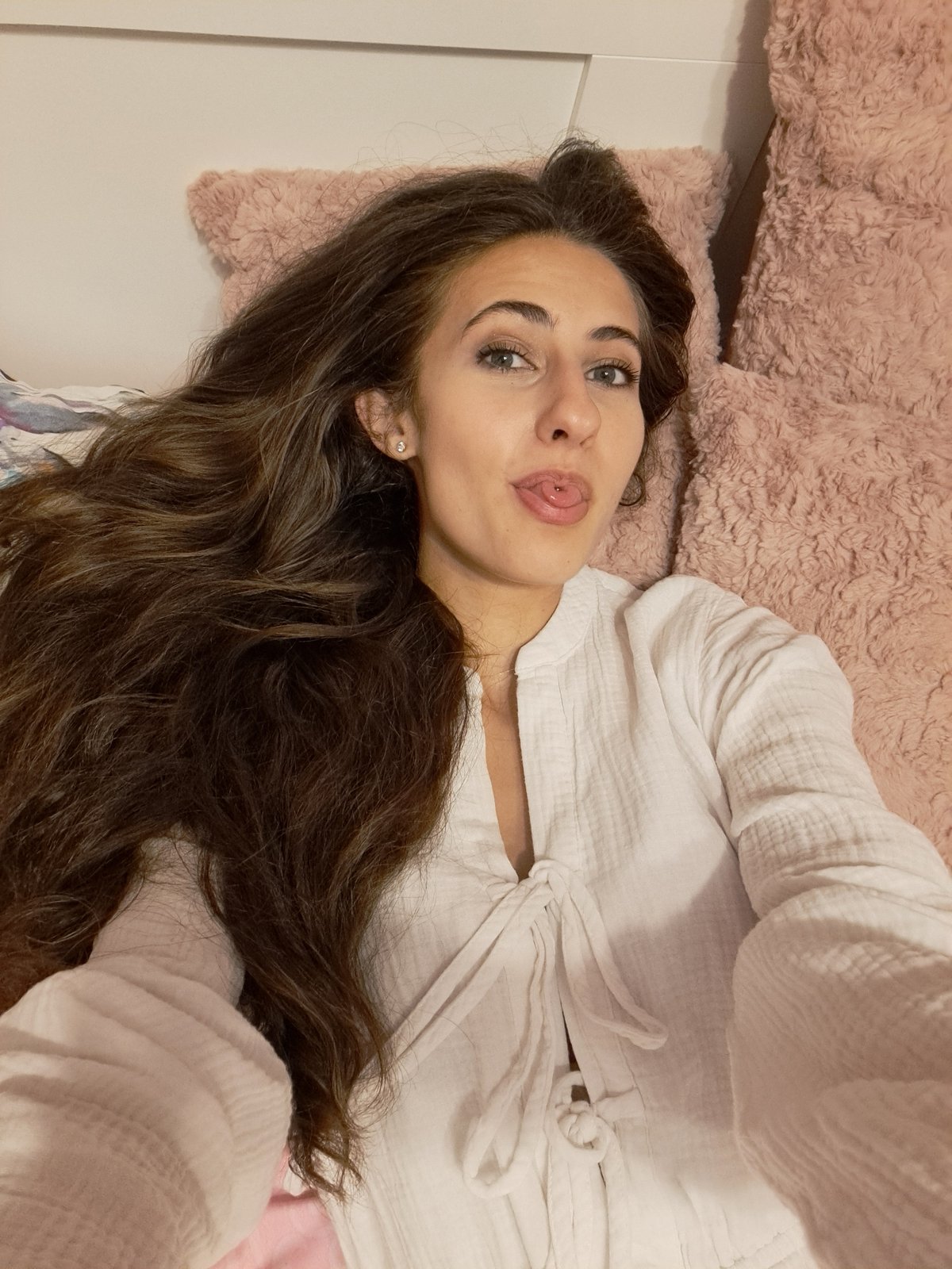 Woman observed resting on pink surface during evening hours