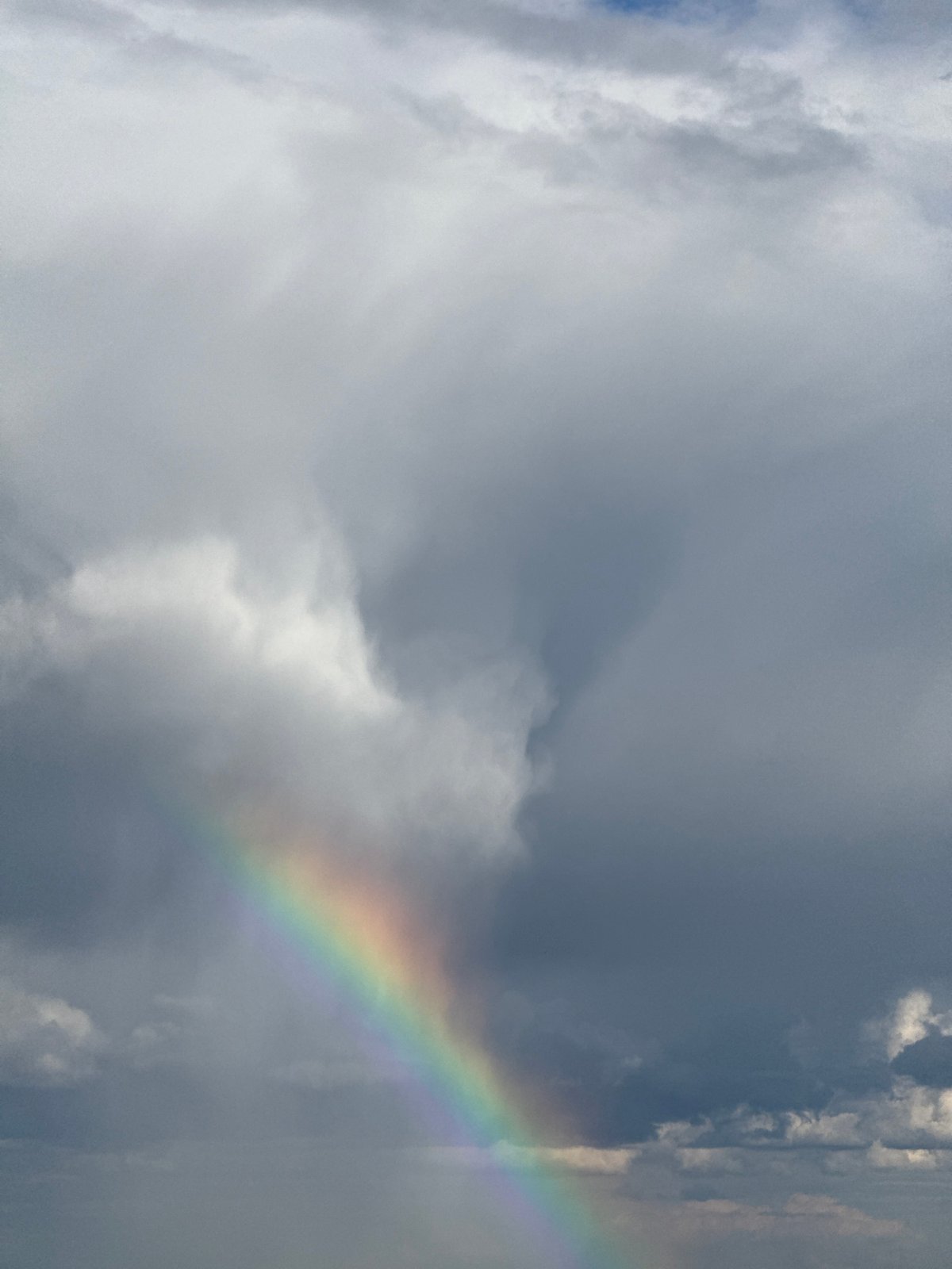 Rainbow appears over Poliudovo, Russia amid cloudy afternoon skies
