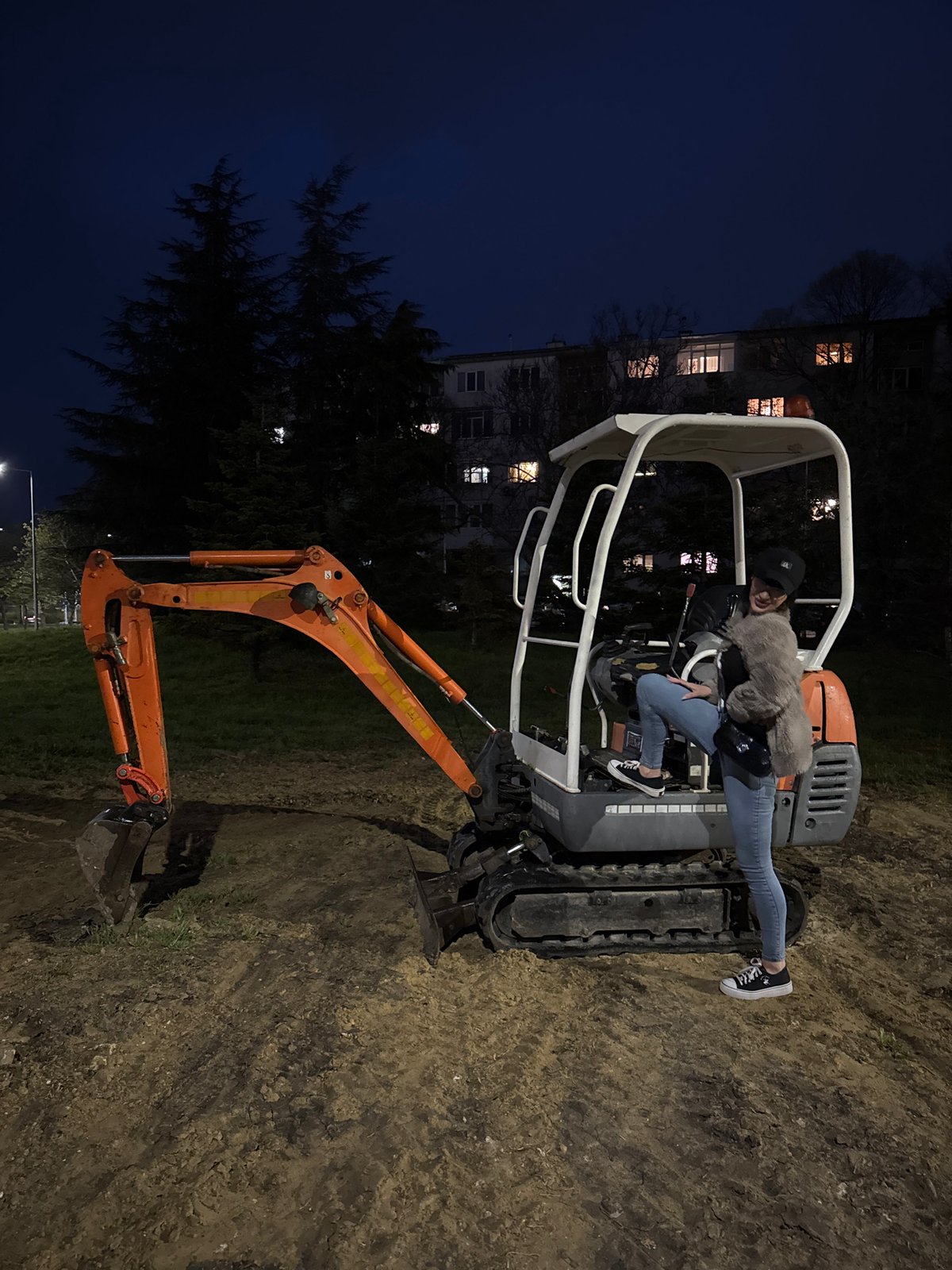Woman poses on excavator at night in Varna
