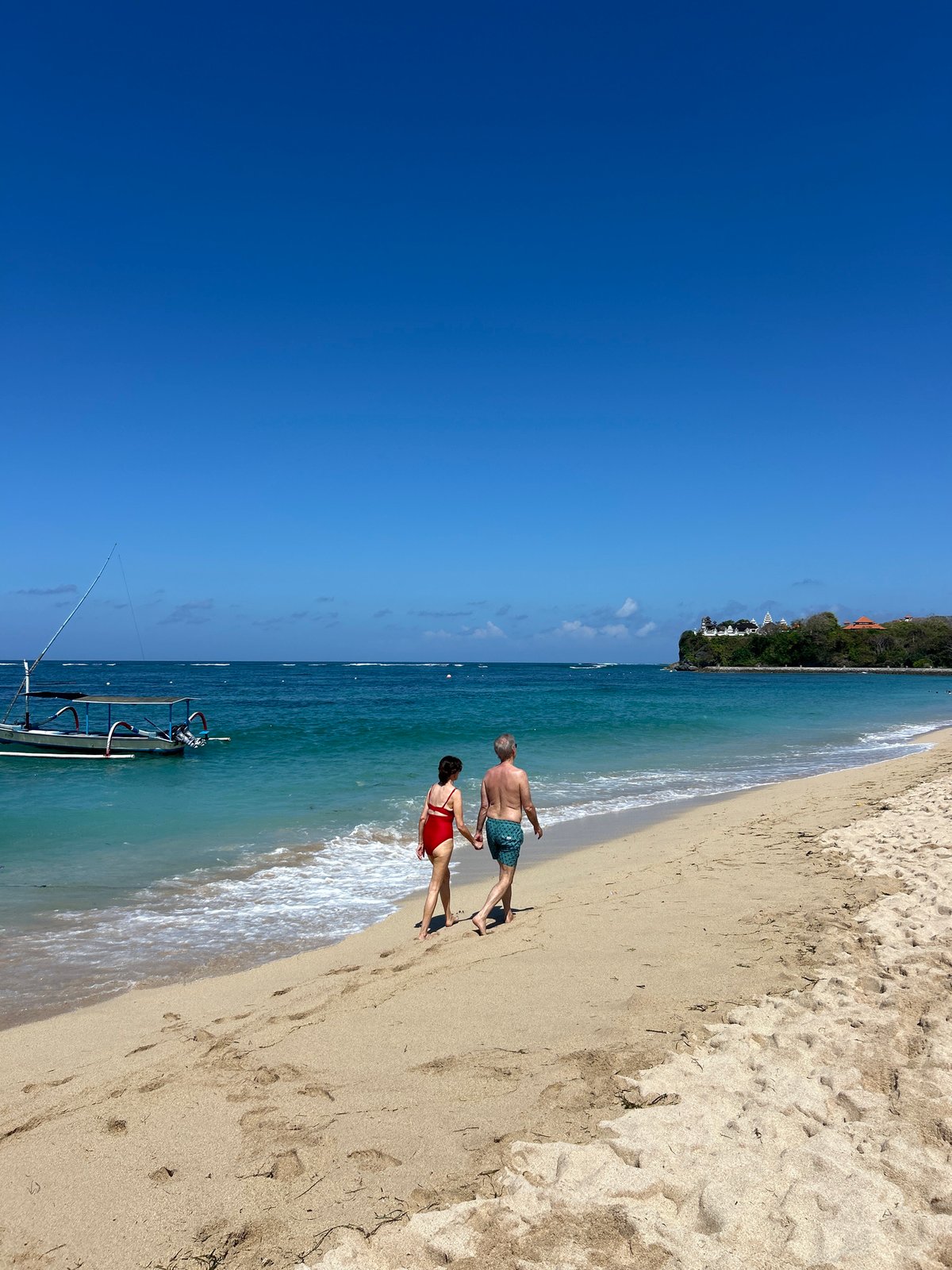 Busy beach day in Kuta Selatan with clear skies and calm seas