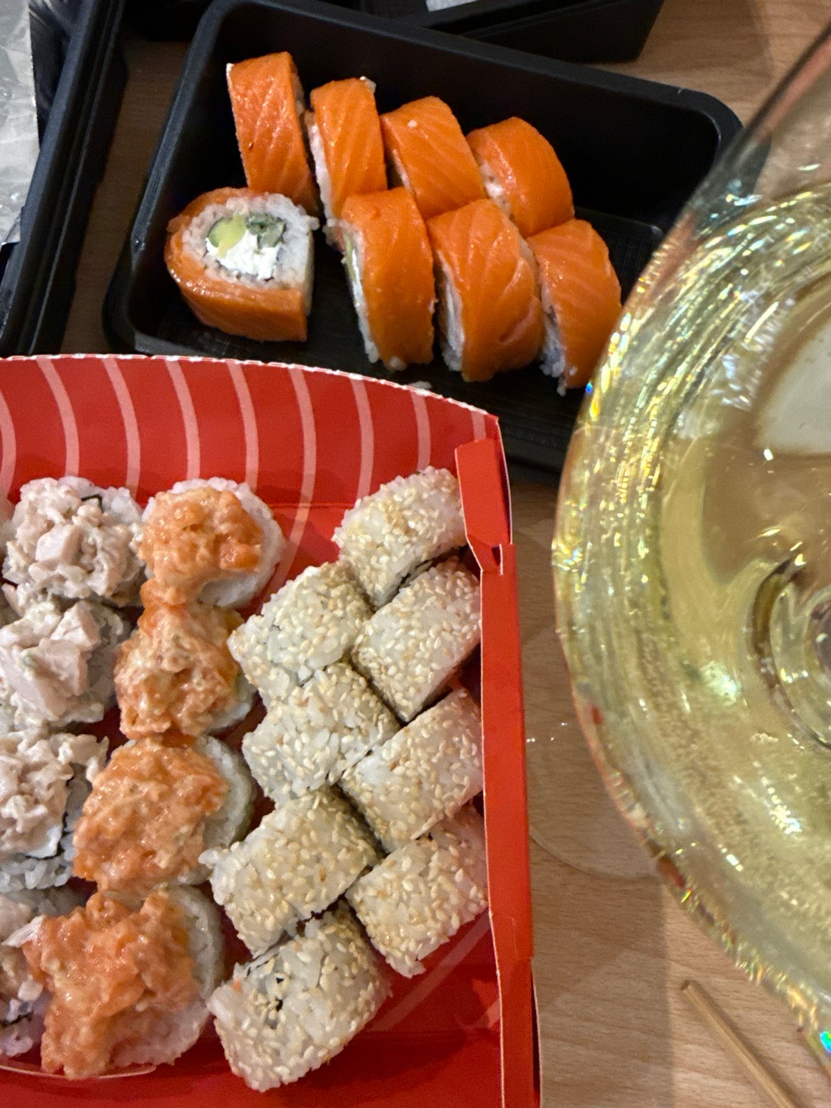 Sushi containers photographed on wooden table in Kazan