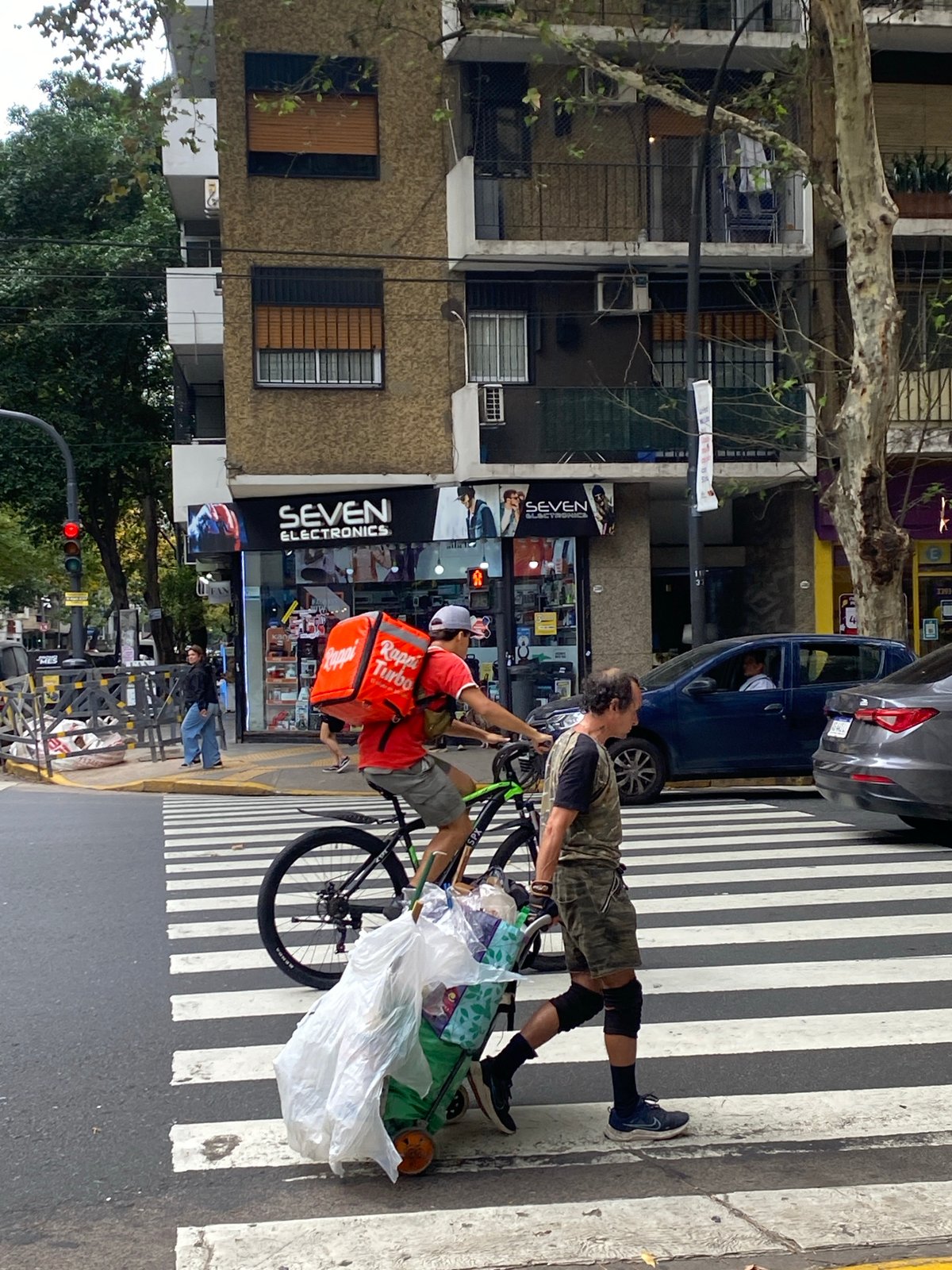 Buenos Aires street activity includes delivery cyclists, construction work