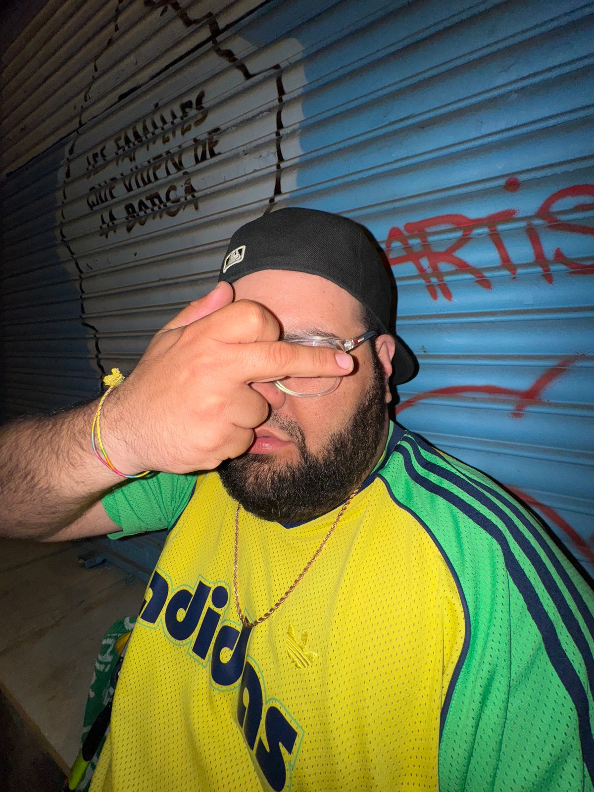 Person photographed against metal shutter in Barcelona nighttime scene