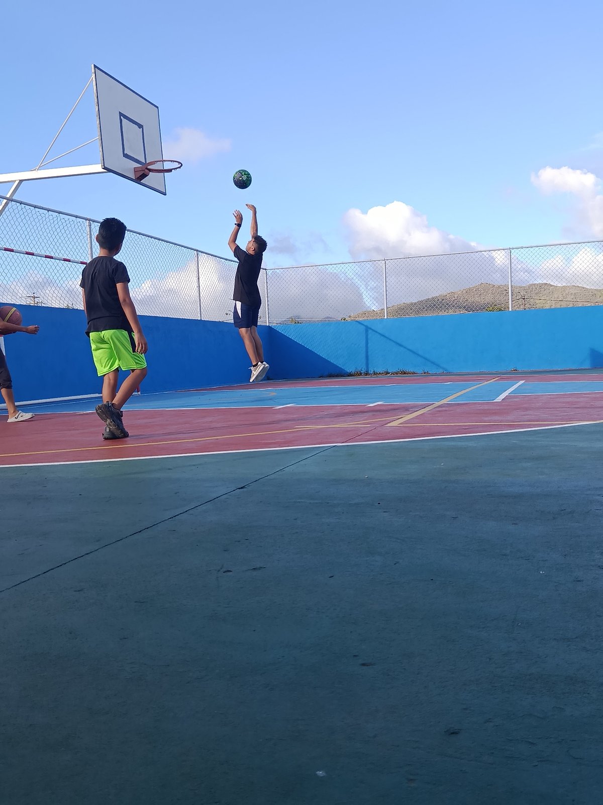 Kids play basketball on a dusty court in Juan Griego