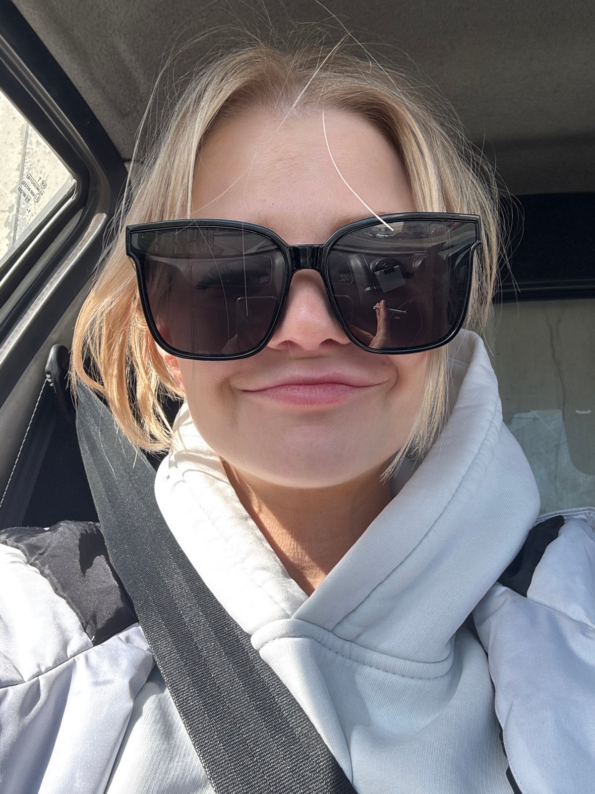Person in sunglasses photographed in vehicle, Saint Petersburg