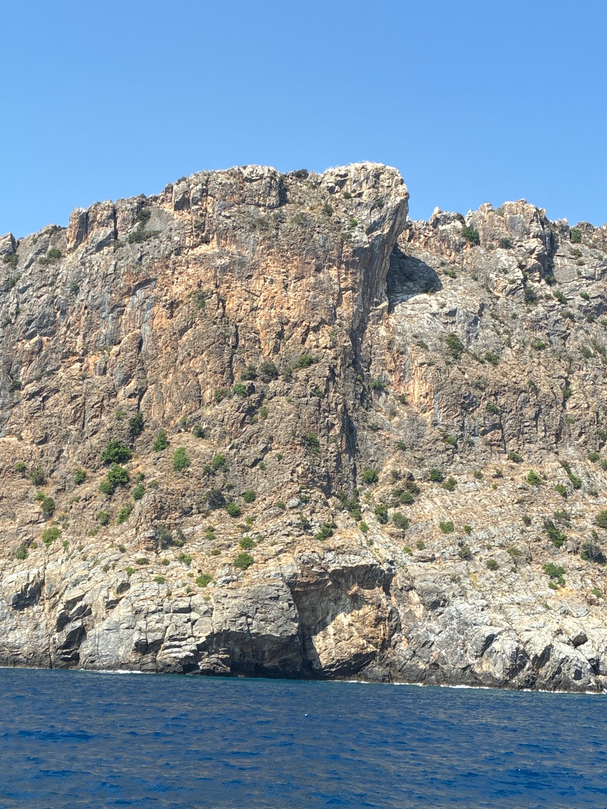 Rugged coastal cliffs meet clear blue sea in southern Turkey