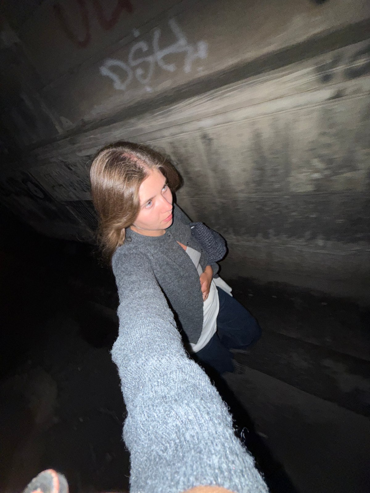 Woman takes selfie in underground concrete structure in Belgrade