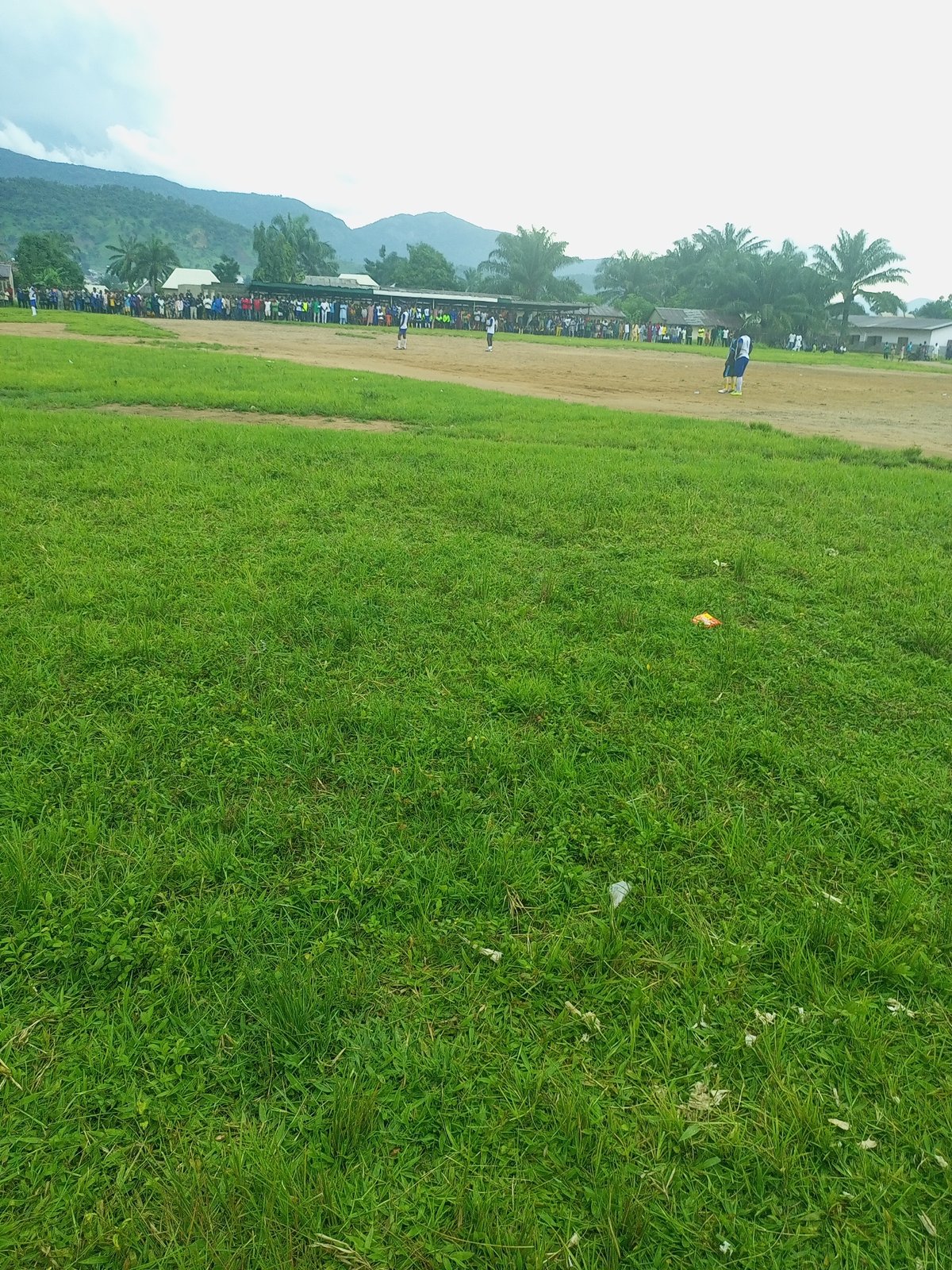 Casual gathering and football on a grassy field in Serti