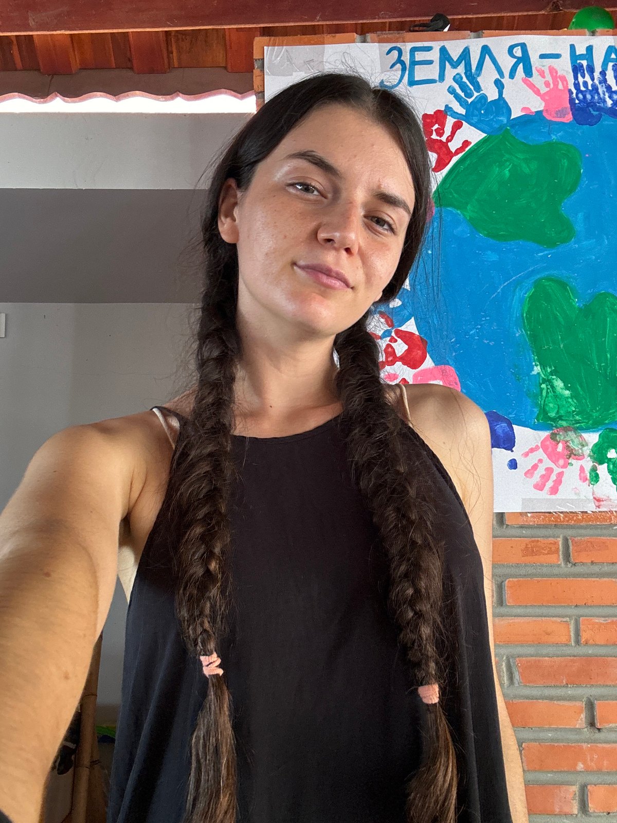 Person with braids photographed near banner in Mũi Né