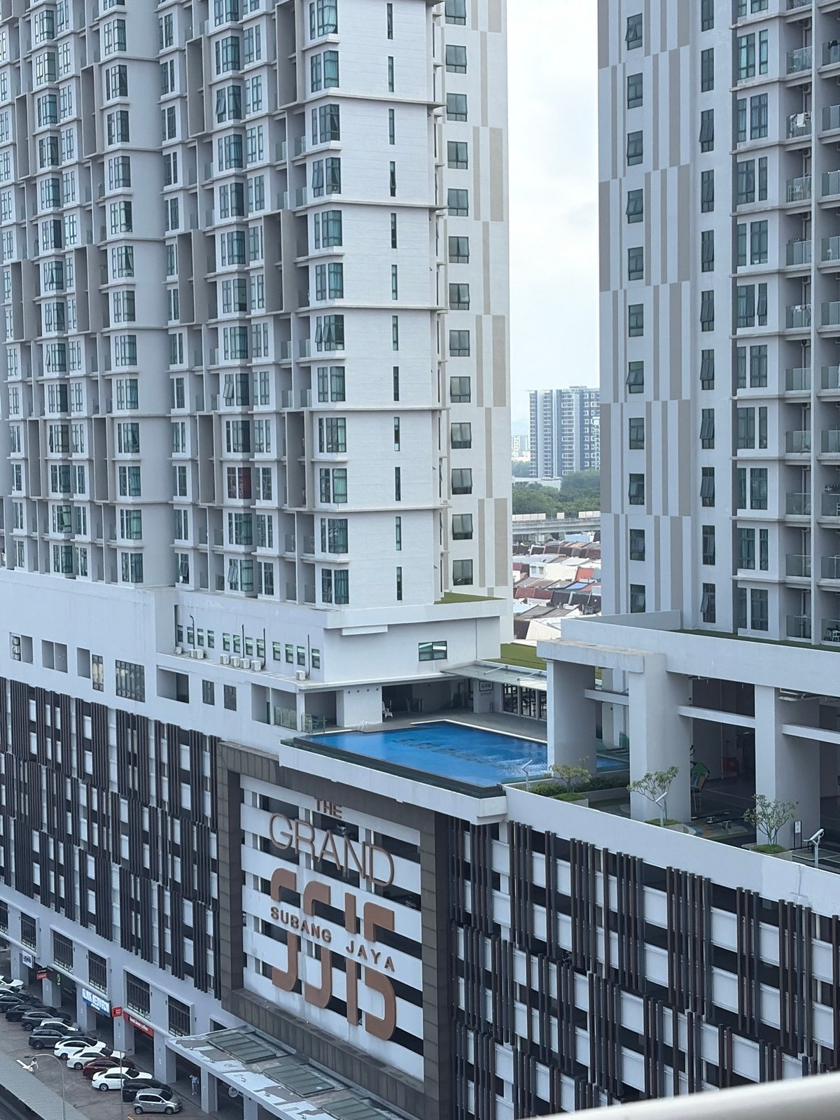Twin residential towers rise over Subang Jaya's urban landscape.