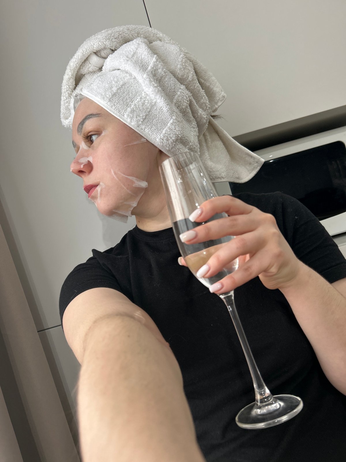 Woman enjoys champagne during morning skincare routine in Russia