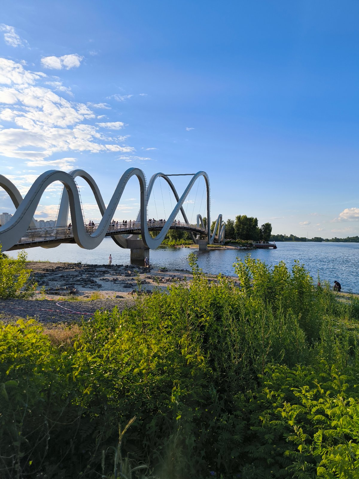 Kyiv's sculptural pedestrian bridge on a busy summer afternoon