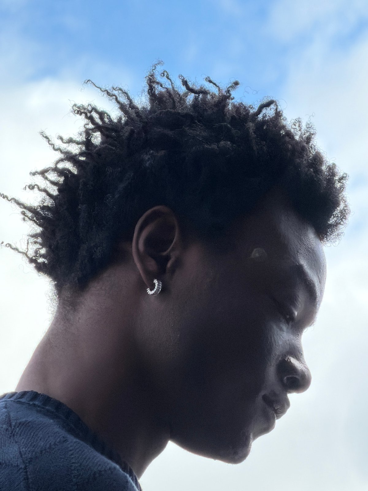 Person photographed gazing upward at cloudy London sky