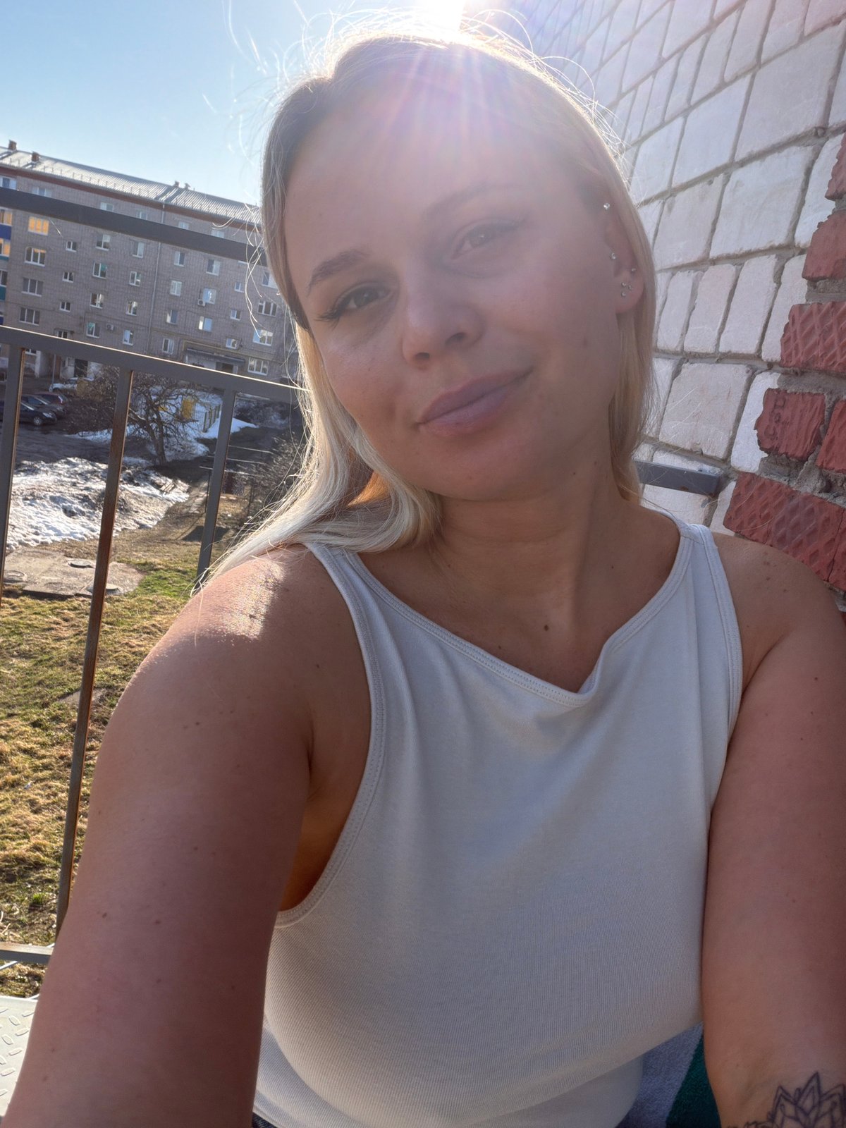 Woman takes selfies while snacking on balcony in Sarapul