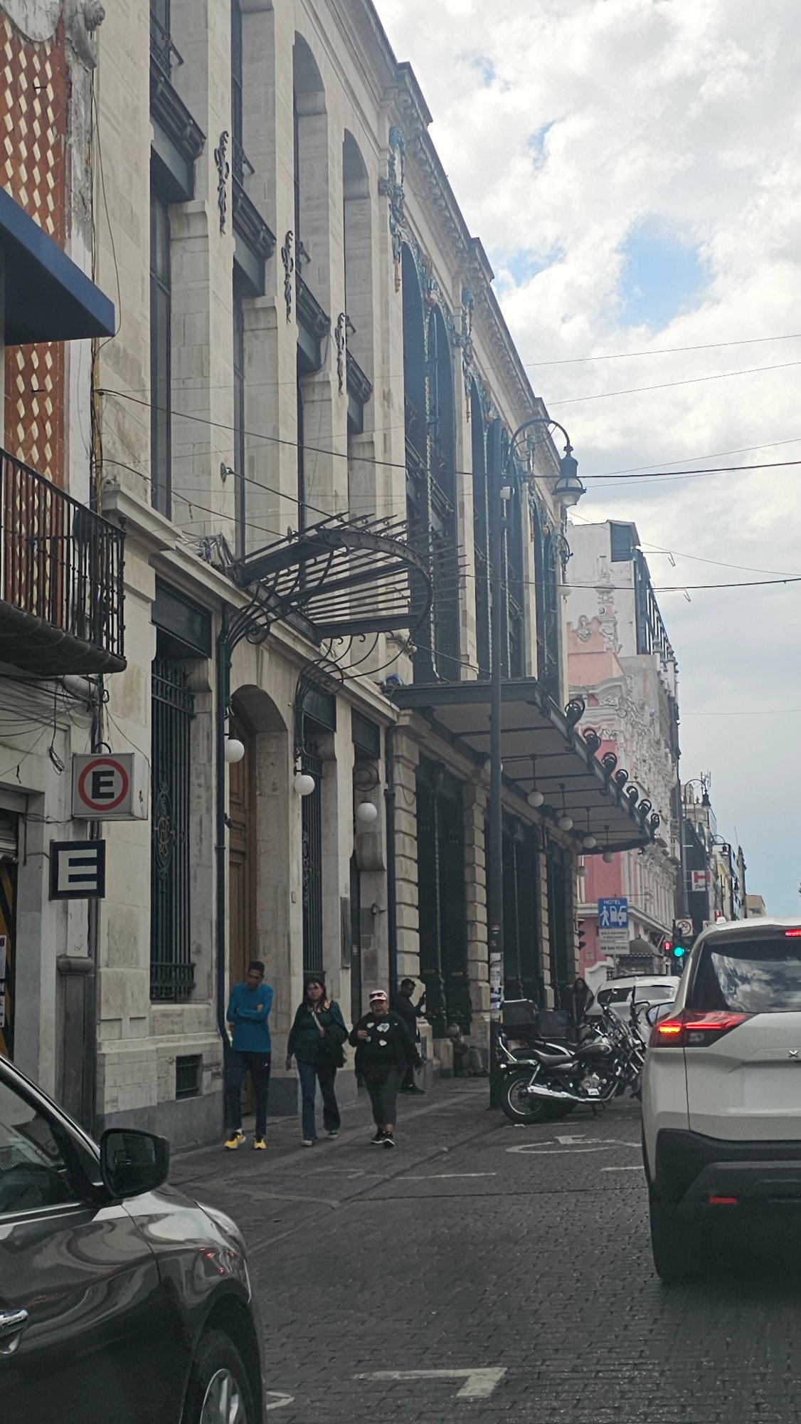 Street scene captured in Puebla showing white architectural building