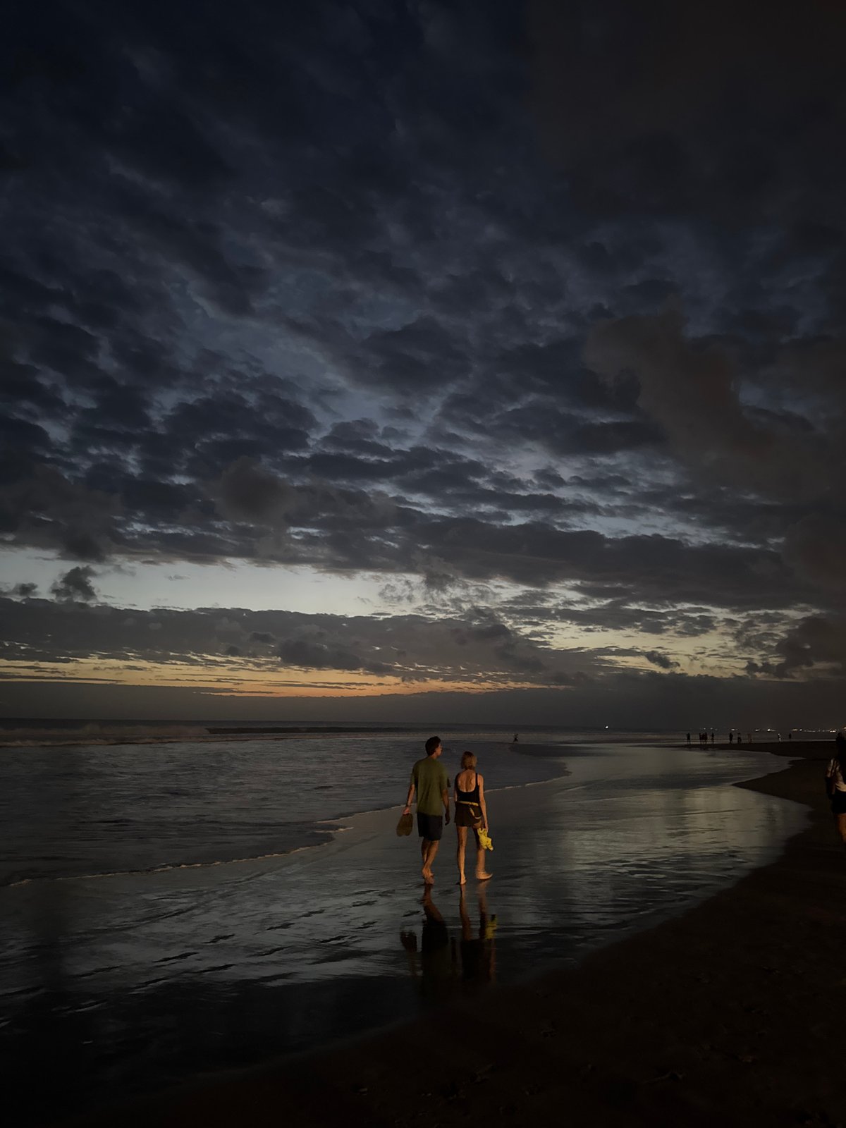 Evening beach life unfolds at Kuta during dramatic sunset