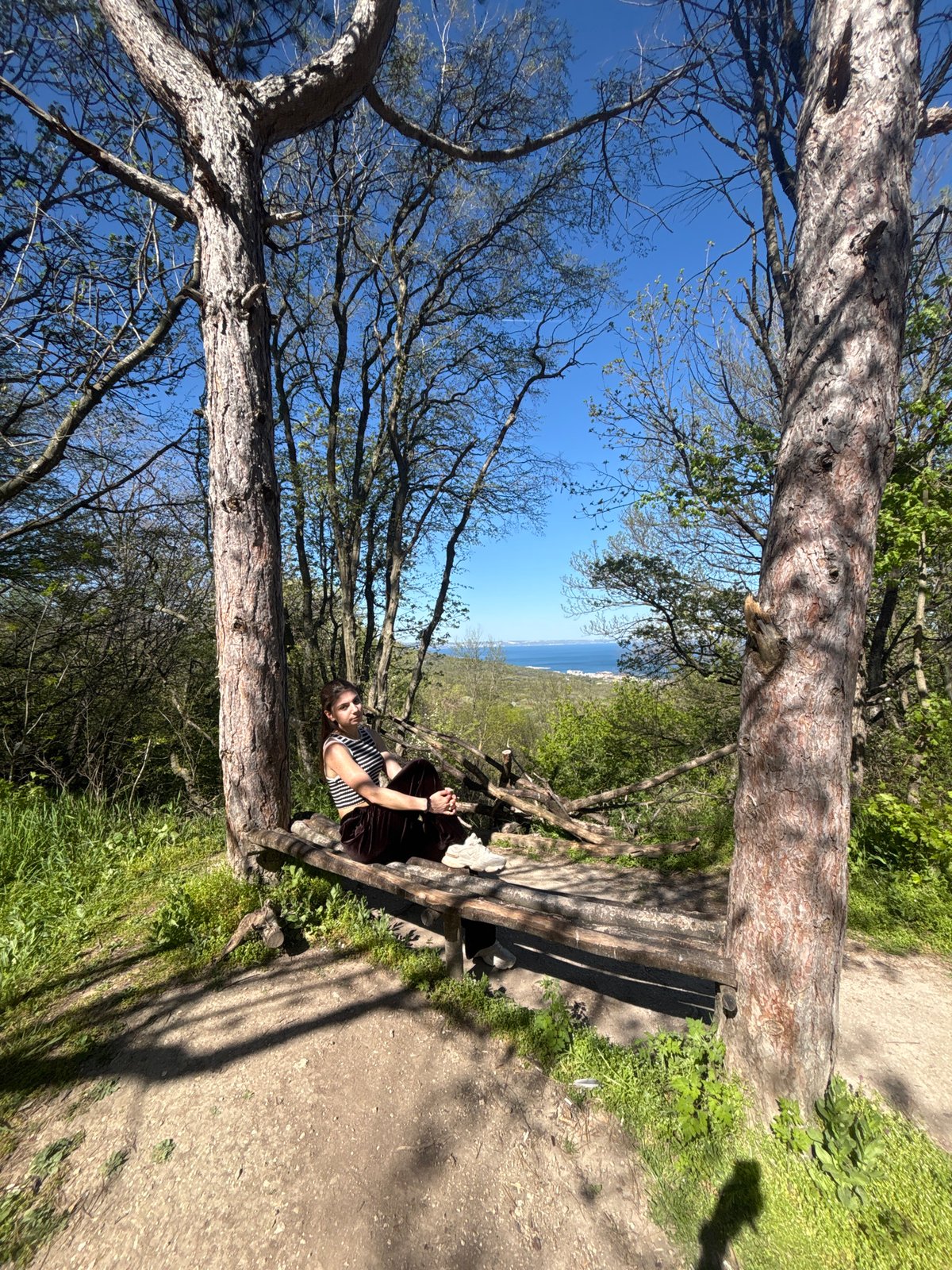 Woman enjoys rope swing, benches in coastal woods near Varna